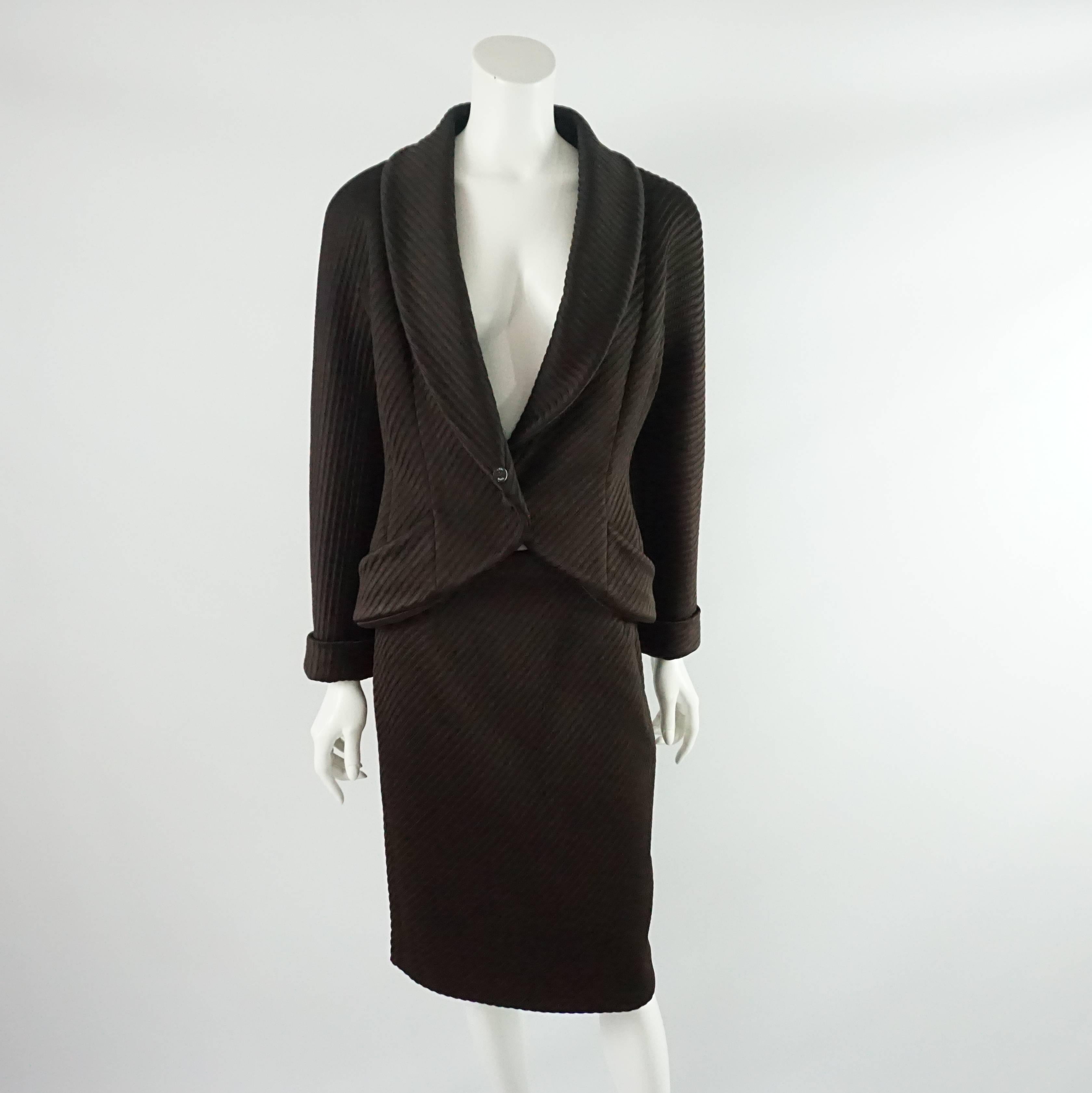 This Fendi chocolate brown skirt suit is made up of a ribbed viscose-rayon knit fabric with a removable Fisher fur collar. It has a single woven button closure with two front pockets on the jacket. The skirt has a side slit and back zipper. The