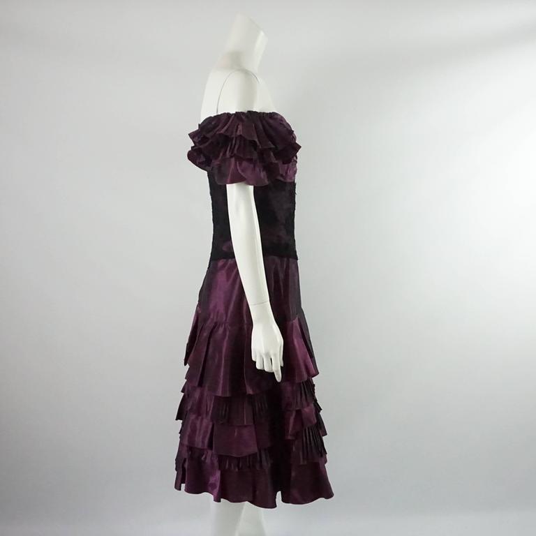This Vicky Tiel dress is a stunning vintage piece with pleated silk taffeta on the skirt and sleeves. The bodice has lace and the bust has ruched fabric. The dress also has boning on the inside and a back zipper. It is in excellent condition with