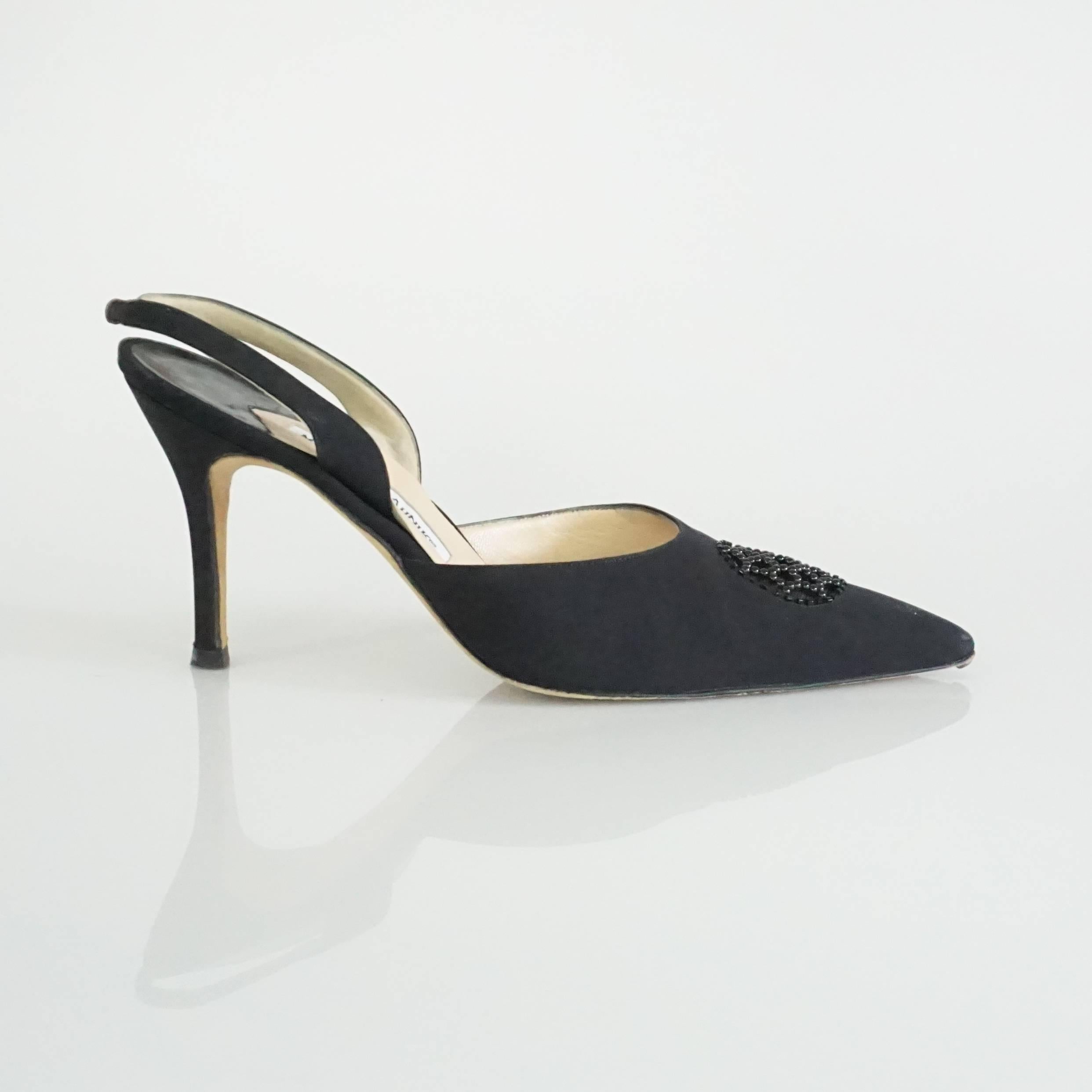 Manolo Blahnik Black Beaded Carolyne Heel - 39.5. These Manolo Blahnik black fabric heels have a mesh beaded front and a slingback strap. They are in good condition with some wear at the front of the toe on the bottom sole, and very faint wear to