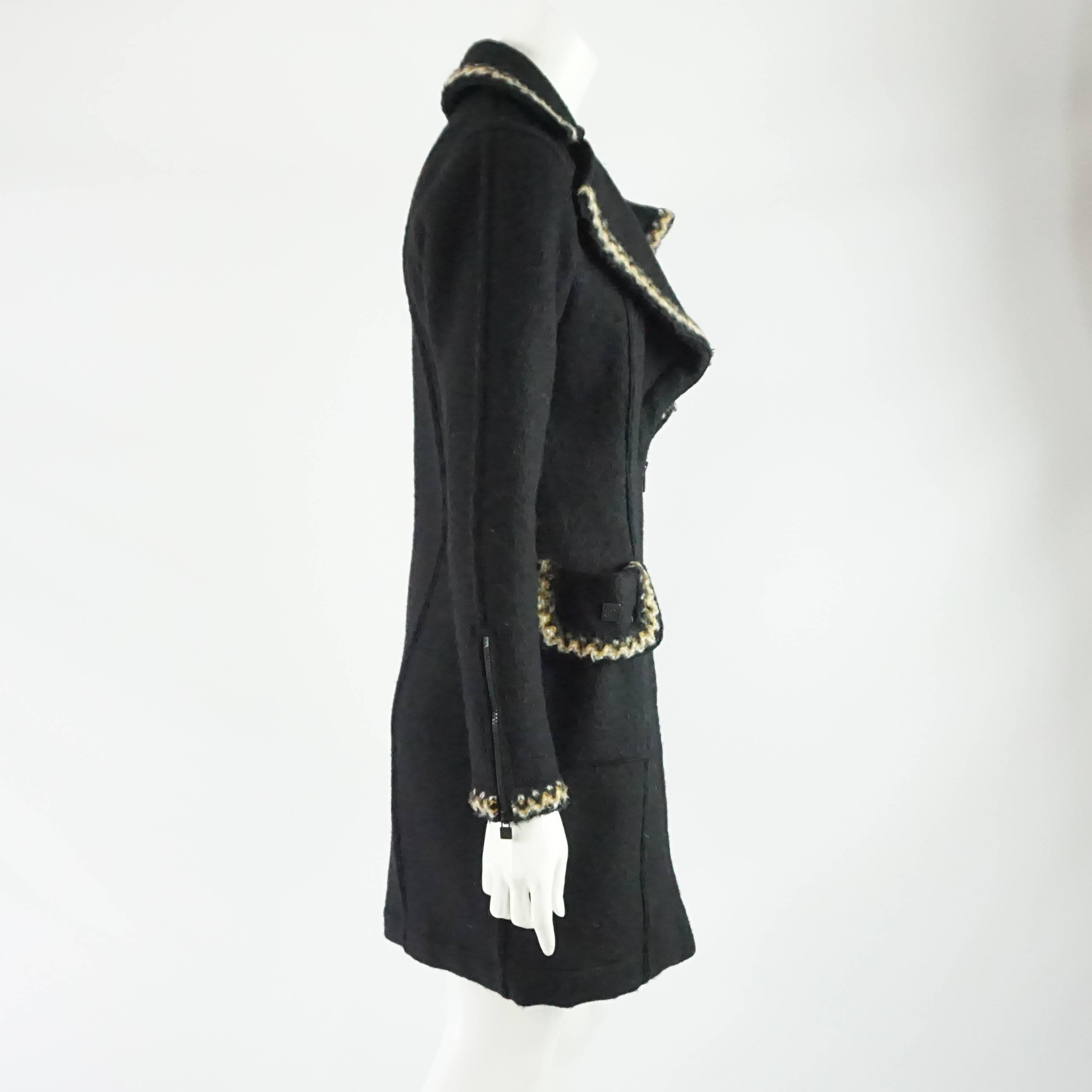 This Chanel black 3/4 coat is a wool-alcapa blend with a white and beige trim. The coat has a thick collar, 2 front double pockets, and black zipper closures. The coat is in good condition with some general wear to the fabric. Size 36,