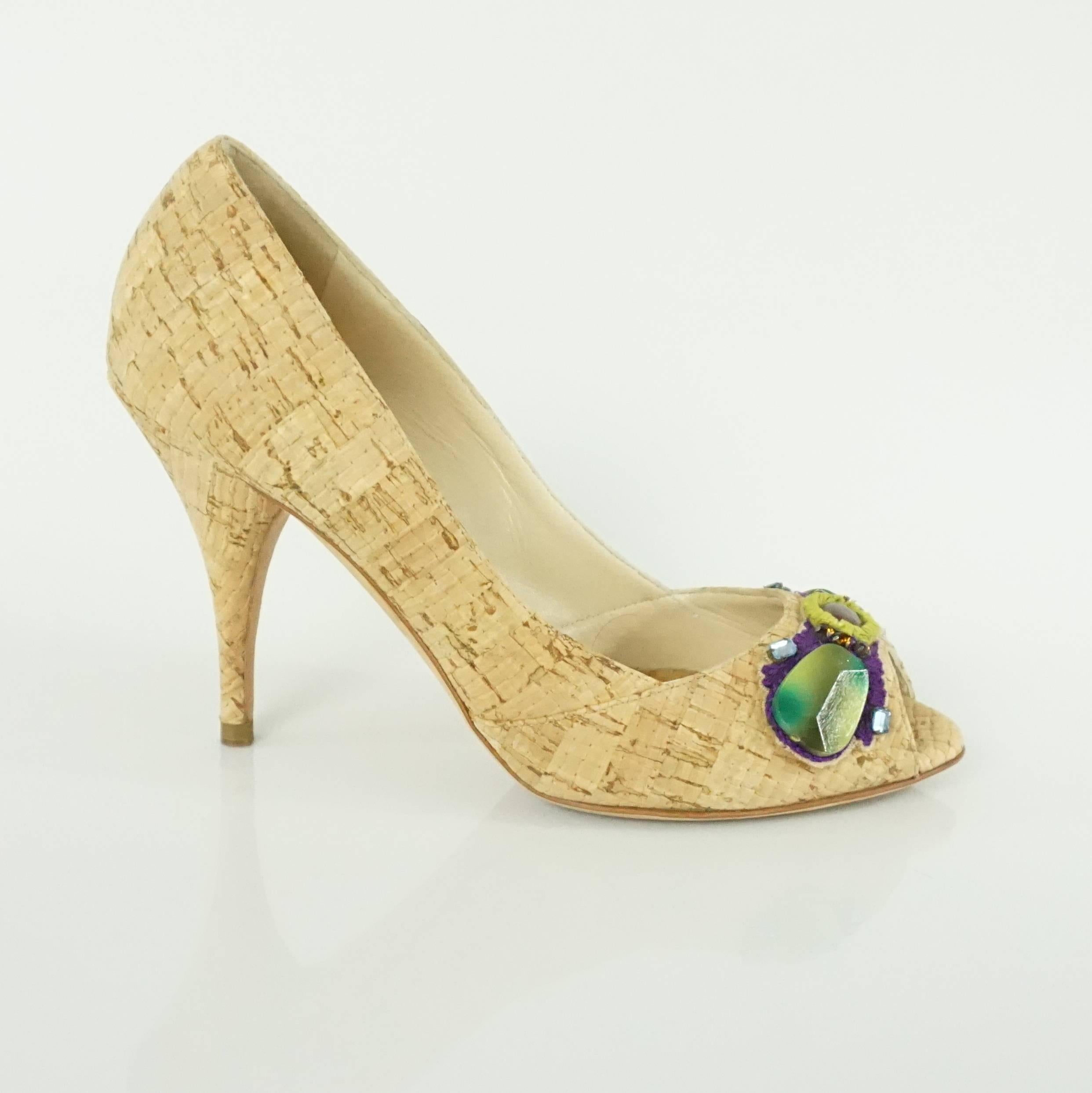 These Oscar de la Renta cork heels have a tropical chic feel. They have a peep toe and embroidered, rhinestone, and stone cluster in the front. The heels are in excellent condition with some bottom wear and minor marks near the back as seen on the