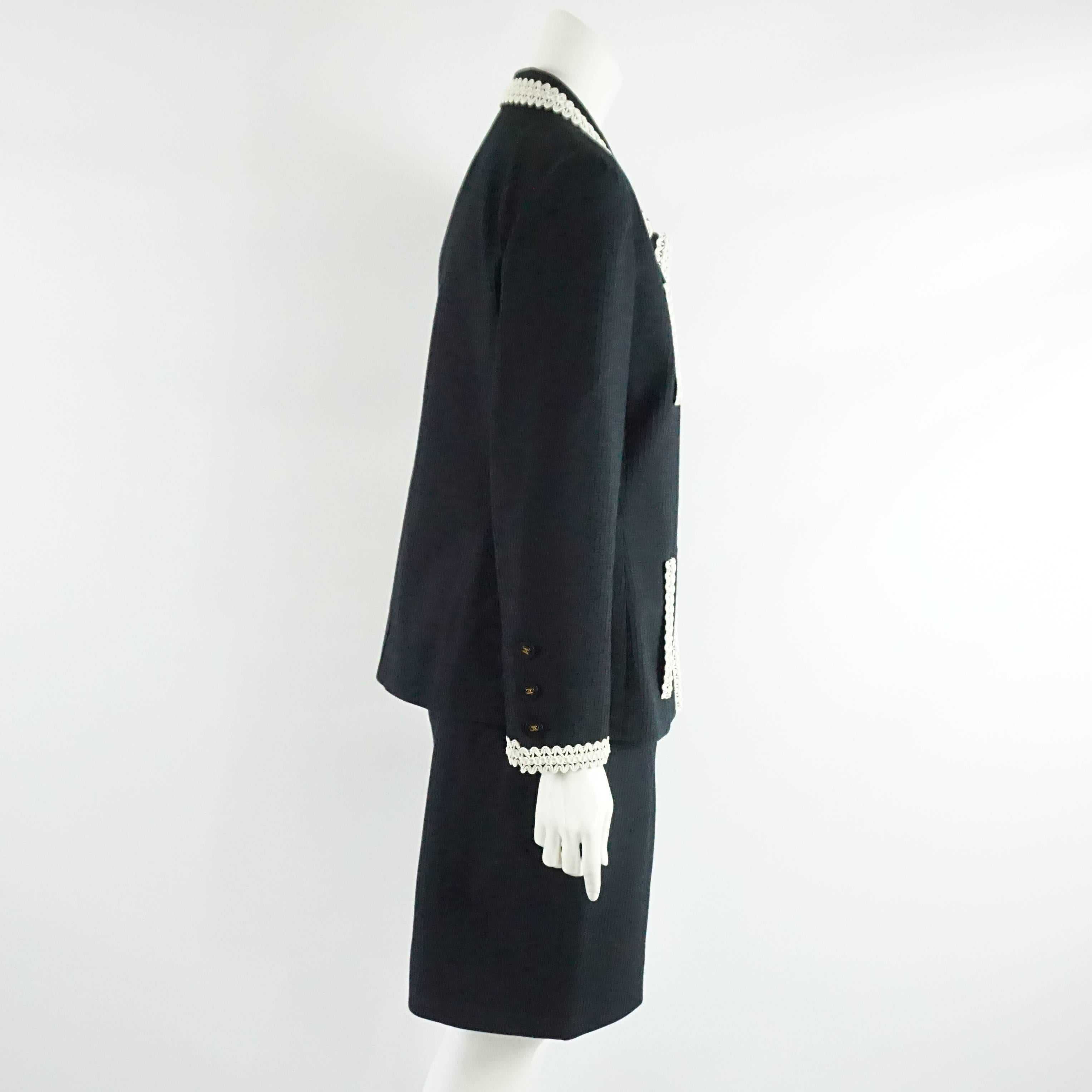 Chanel Navy Textured Cotton Skirt Suit with White Vinyl/PVC Lace Trim Detail - 42 - 94P  This very unusual and spectacular looking vintage skirt suit has a very unique white vinyl lace looking trim along the collar, the front, the sleeves and the 4