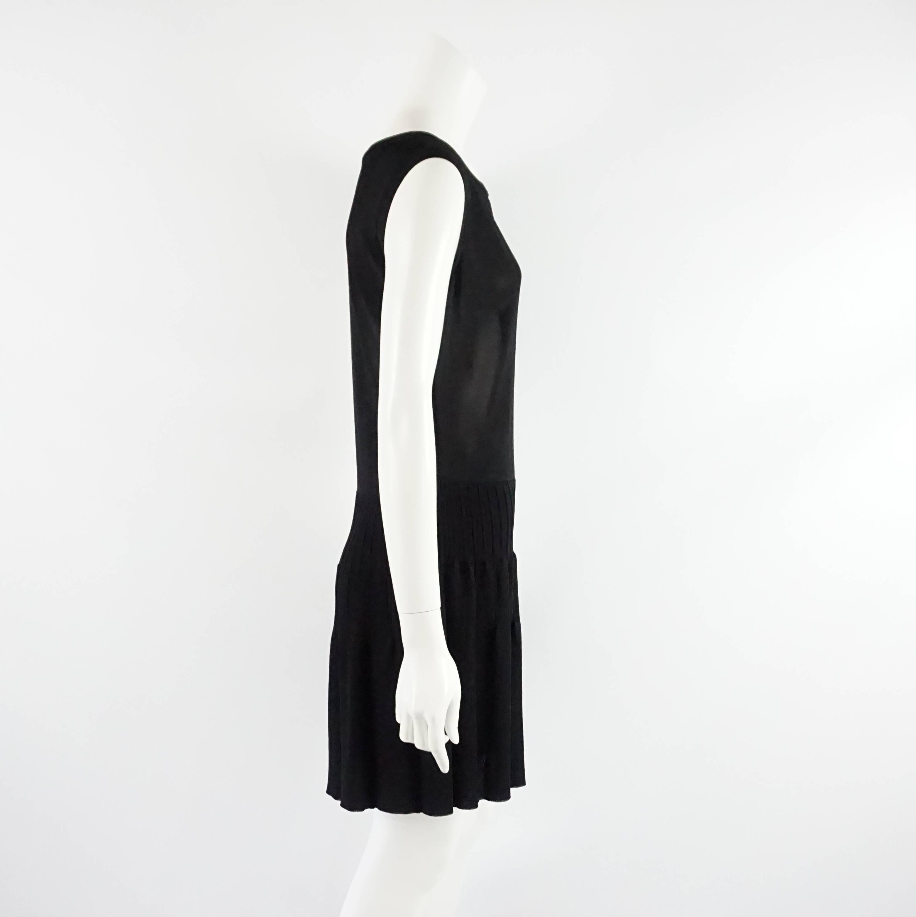 This black Chanel sleeveless knit dress features a slightly sheer top and a black pleated skirt. The top has a Chanel logo detail. This dress is in excellent condition.

Measurements
Shoulder to Shoulder: 16.5"
Bust: 35"
Waist: