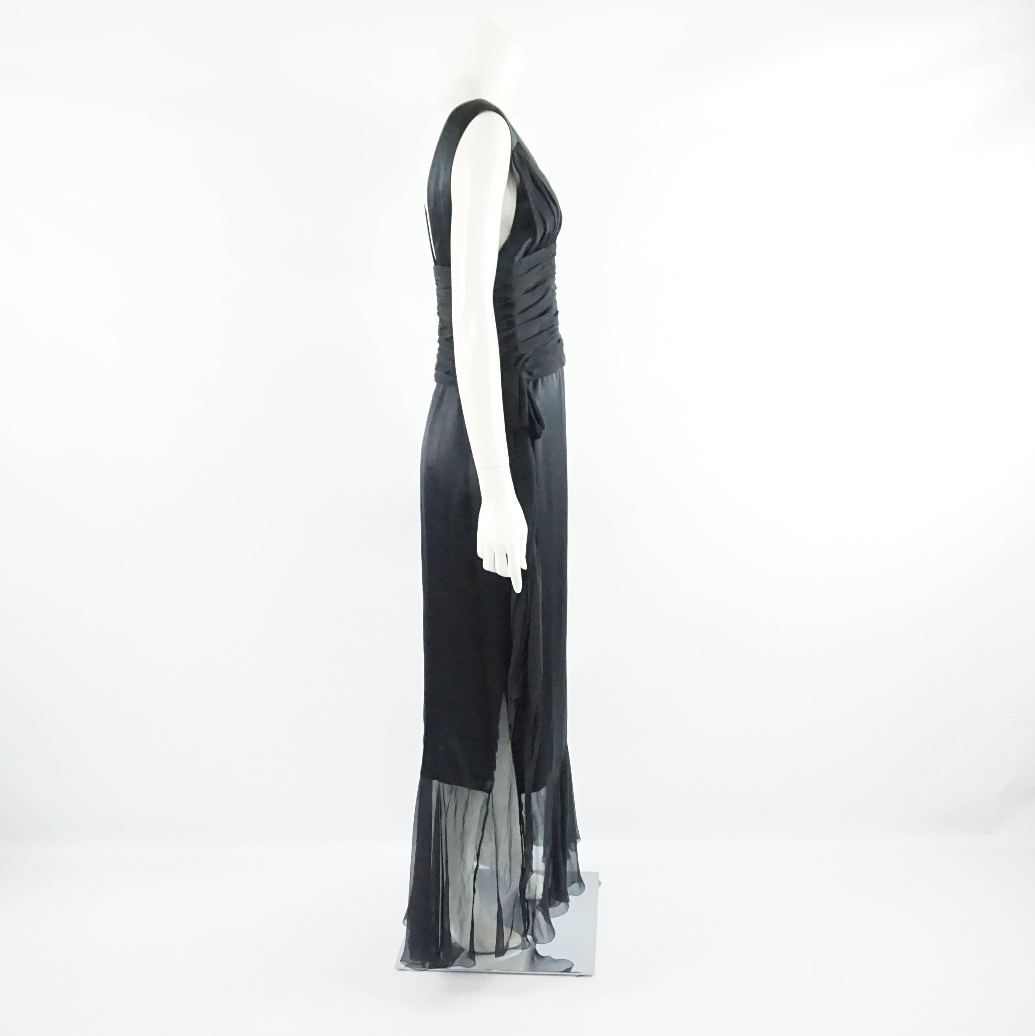 This Chanel silk chiffon gown is black and sleeveless. It features a v-neck and a low back. There is a bow on both sides of the waist. This gown is in excellent condition. It is from the 06A collection.

Measurements
Bust: 36