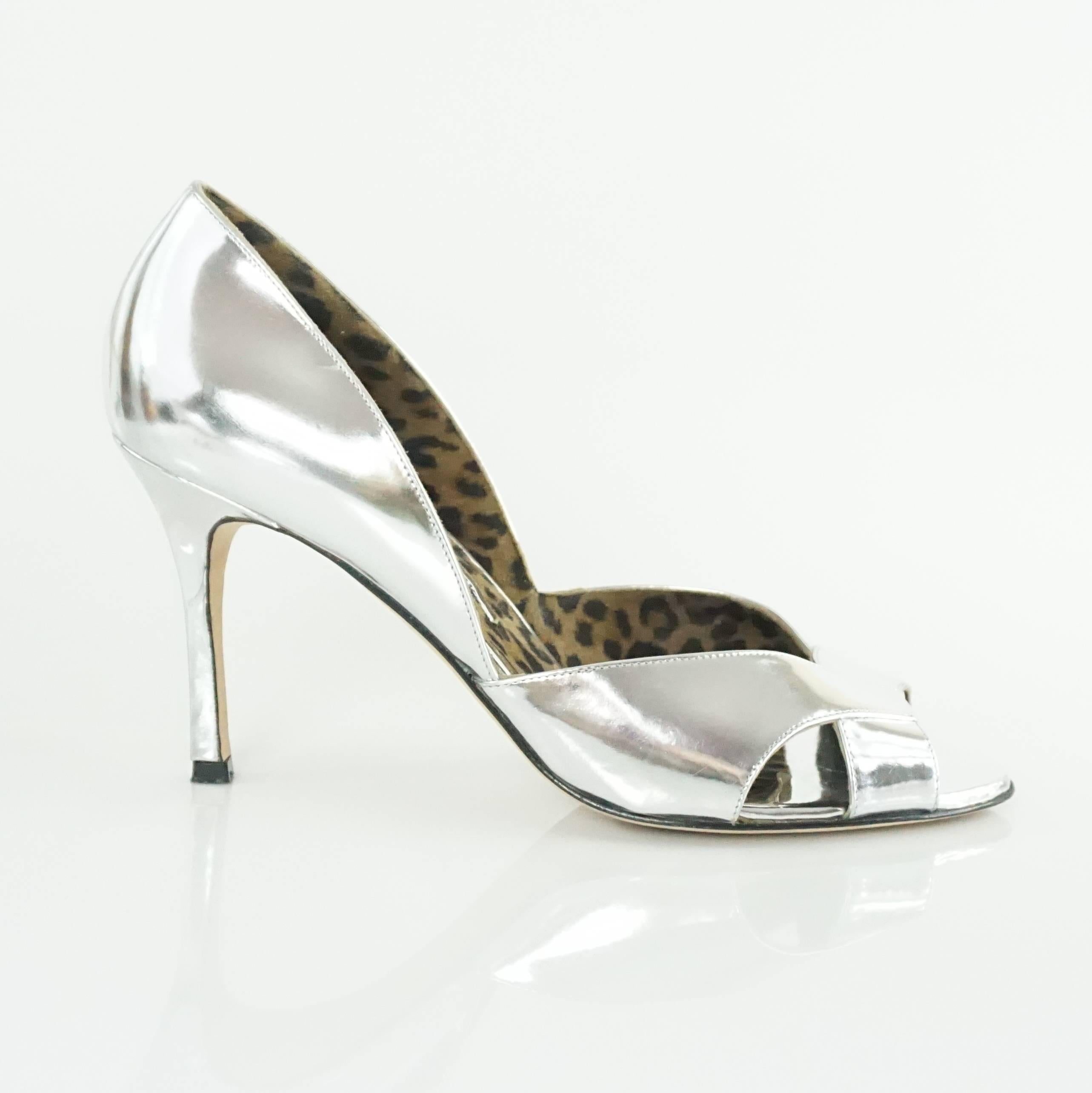 These Manolo Blahnik metallic silver Patent Leather D'Orsay heels have cutouts and an open toe. They are in good condition with minor bottom wear, and some light scratching.

Measurements
Heel Height: 3.5"