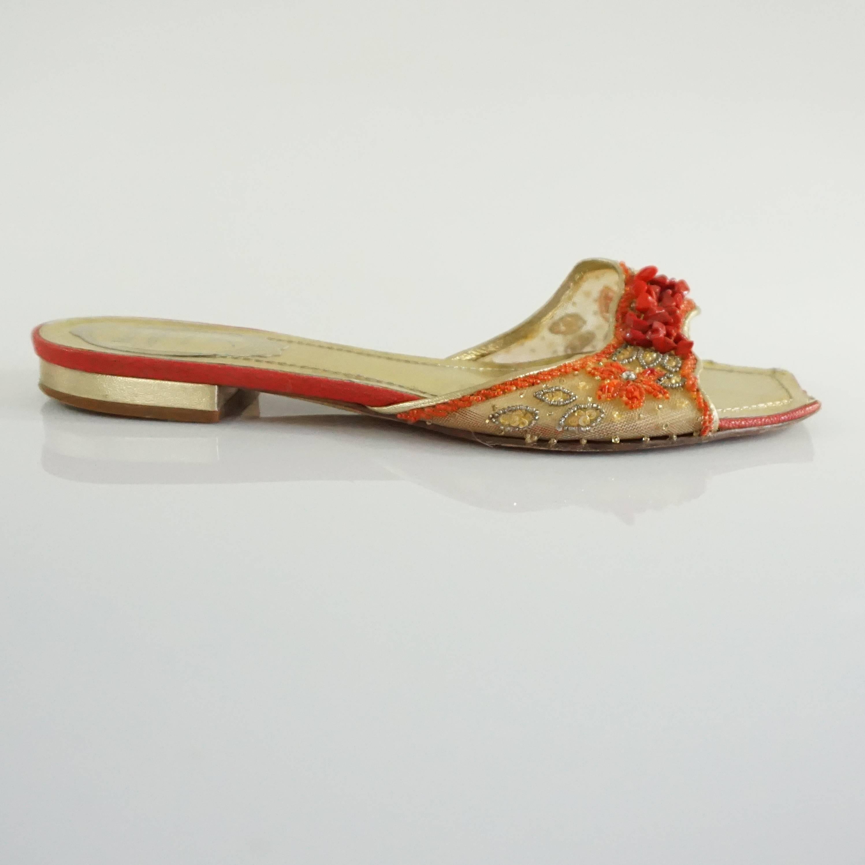 These Rene Caovilla mesh beaded slides are gold and red. They have bedazzlement on the band. They are in good condition with wear on the bottom and scuffing on the front.

Heel Measurement: 0.5