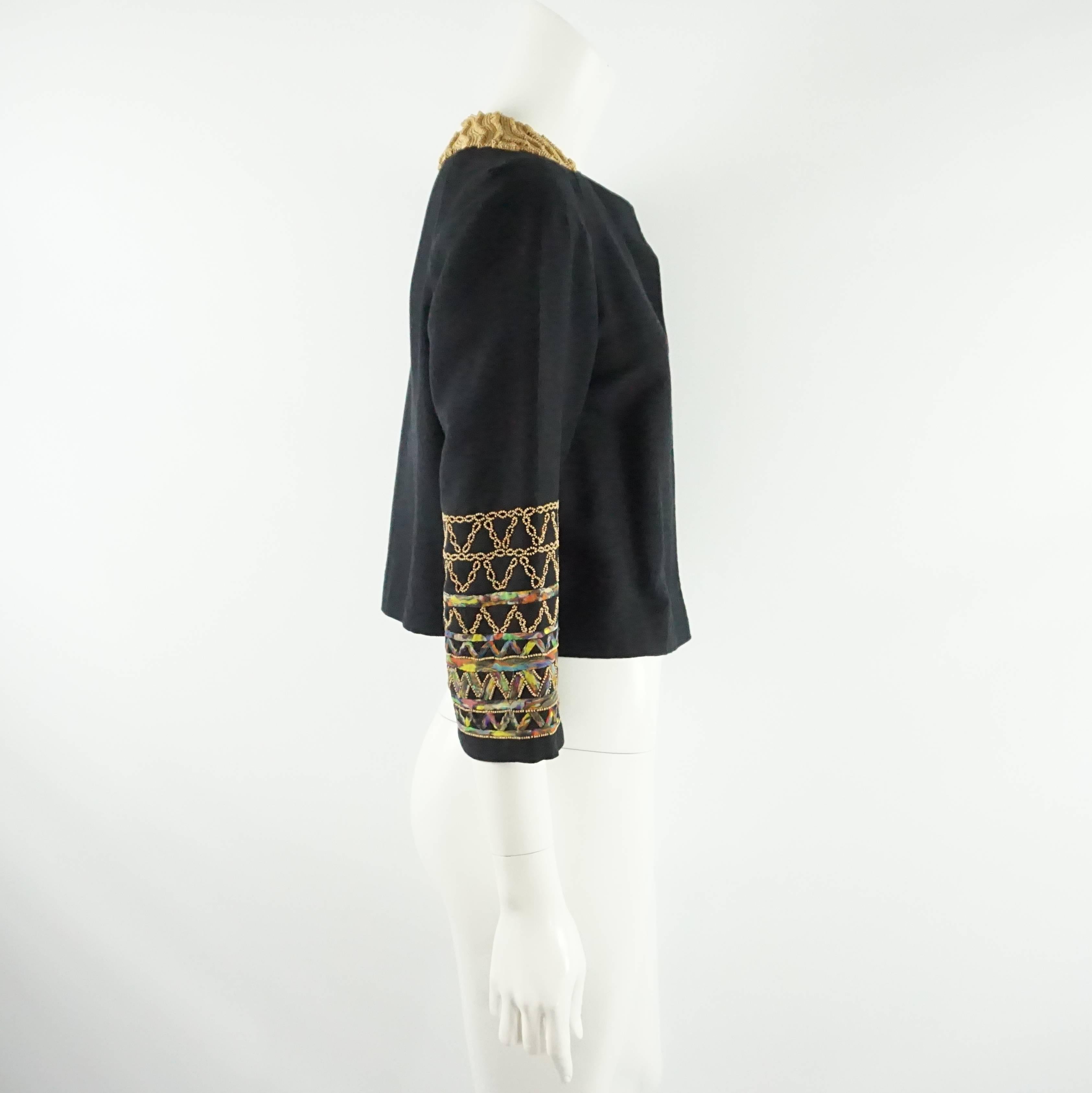 This Dries Van Noten crop jacket is a cotton-wool blend with wood beading on the neckline and sleeves. The sleeves also have a multi ruched fabric stitched into the beaded design. The jacket is in excellent condition with light wear.