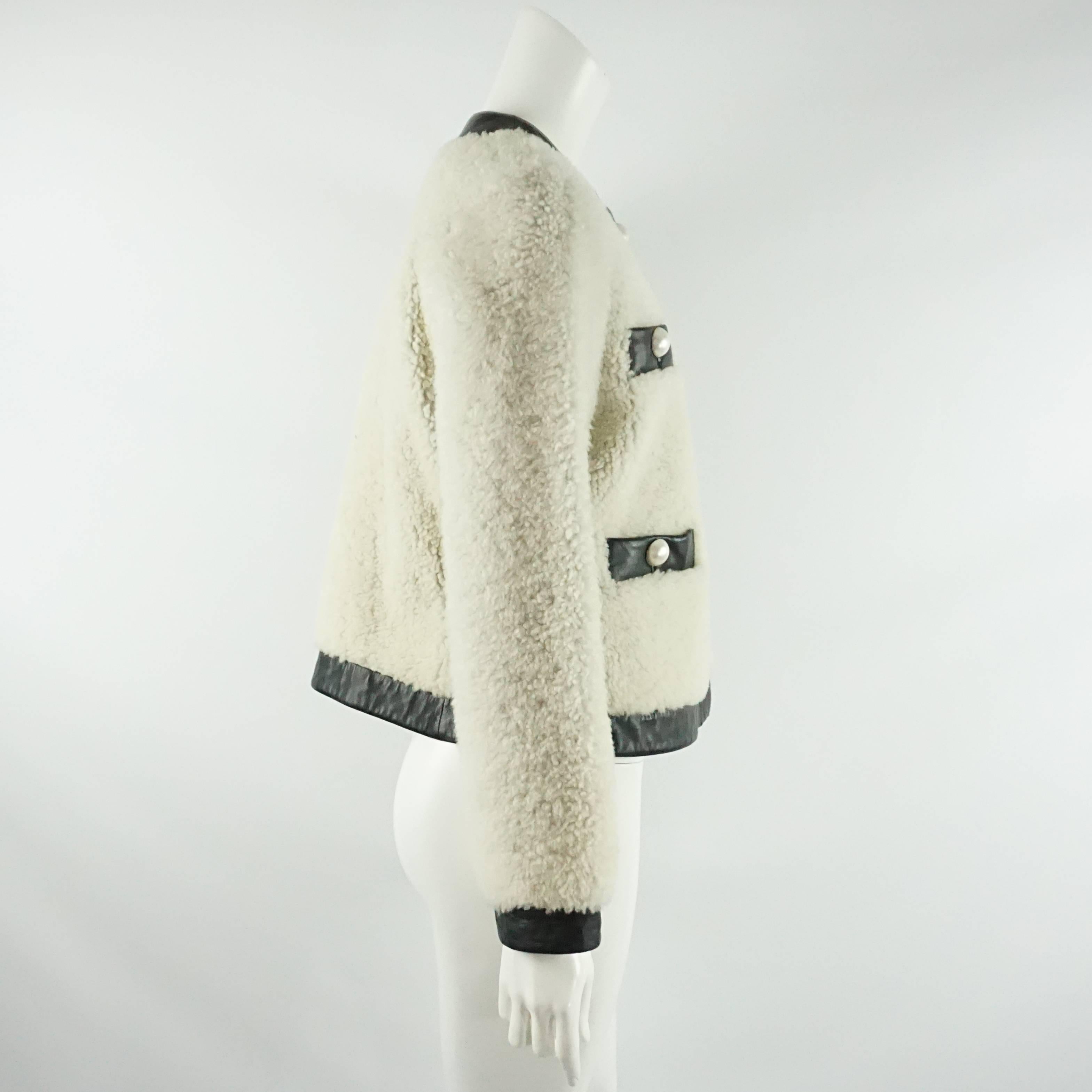 Cette veste en shearling (fourrure de mouton d'Espagne) ivoire de Moschino Cheap & Chic est entièrement garnie de cuir noir de 1,75