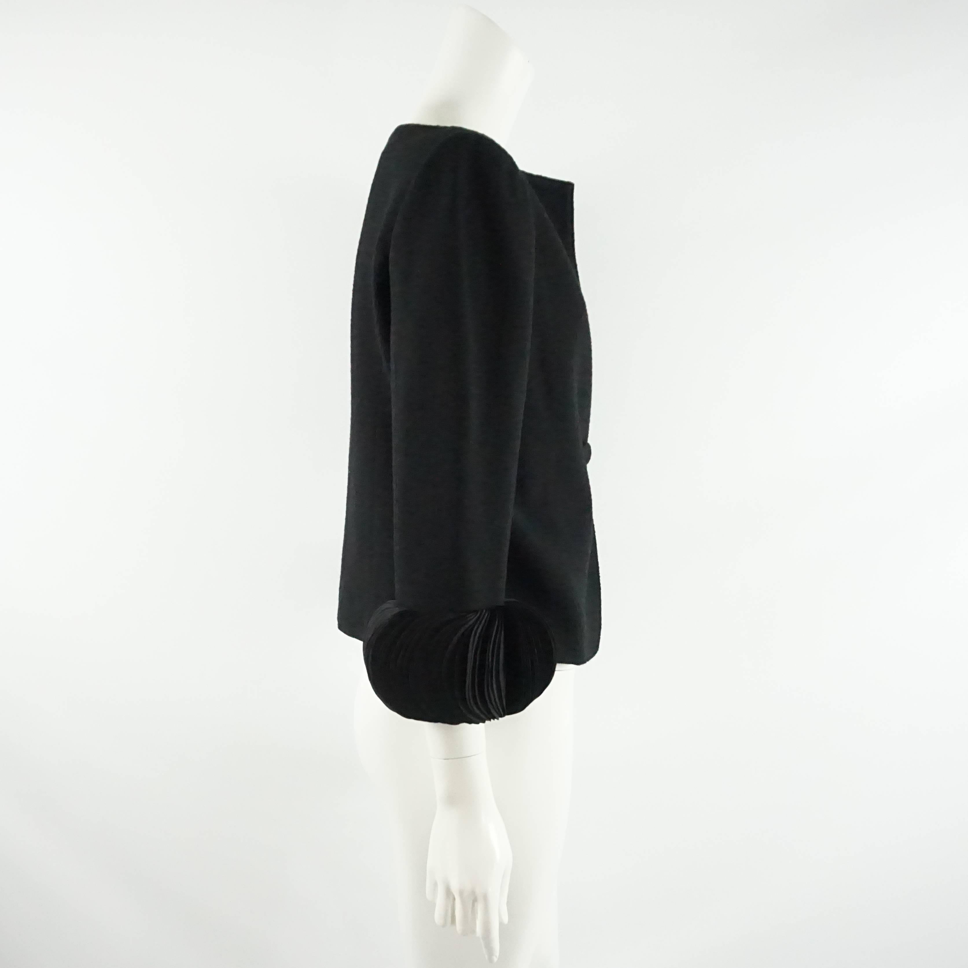 This Valentino wool jacket is black with thick petal sleeves. It has a single button closure and light shoulder apds. This jacket is in excellent condition.

Measurements
Shoulder to Shoulder: 15.75