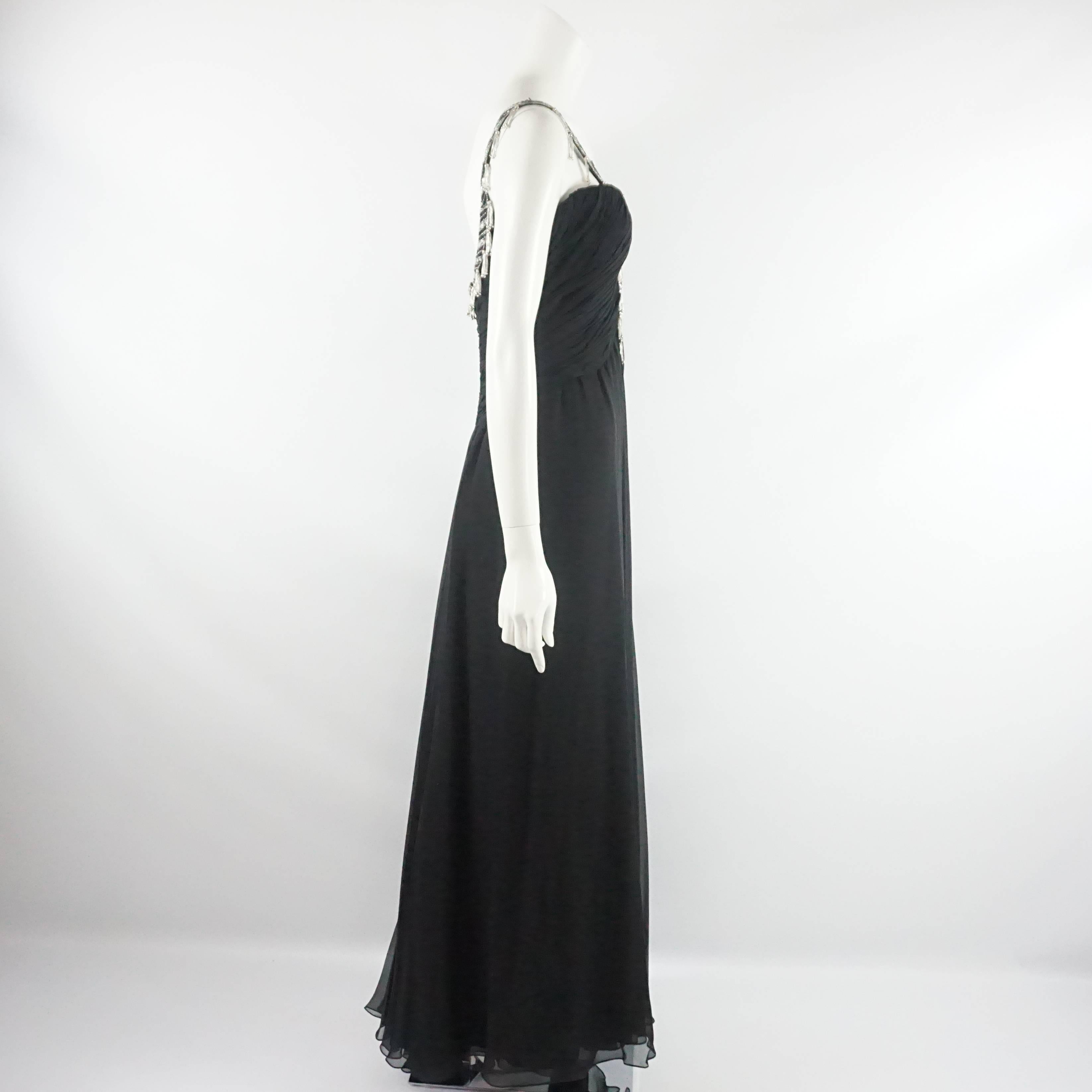 This vintage 1980's Bob Mackie gown is black silk chiffon. It has a halter and v-neck design with hanging beading and tassels. A shawl was made to go with the gown. These pieces are in excellent condition.

Gown Measurements
Bust: 32"
Waist: