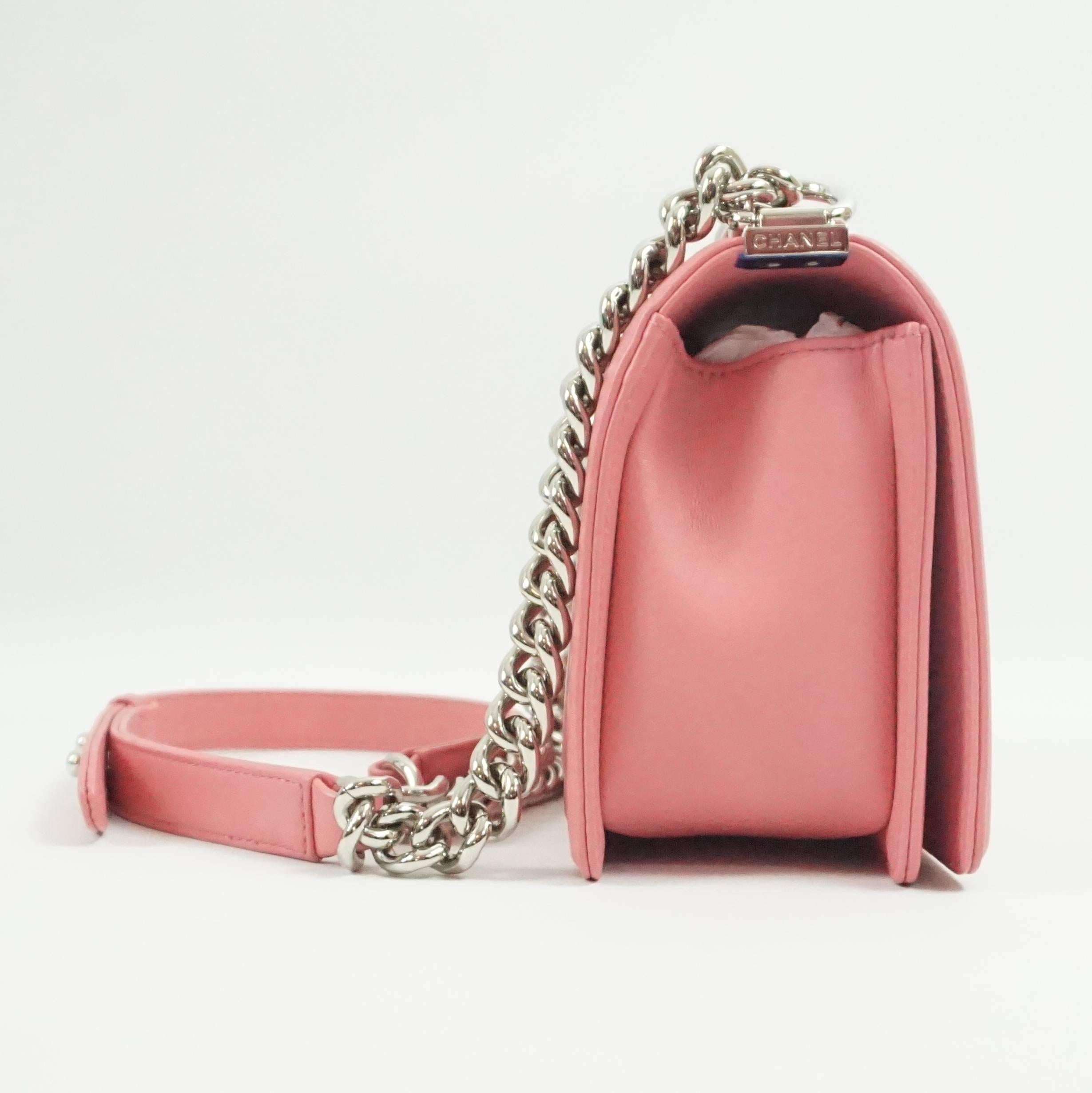 This beautiful Chanel medium 2016 Boy Bag is made of pink quilted leather. The stitching forms a chevron design. This bag has silver hardware and the Chanel logo on the silver detailing on the strap. All of the components are included. This bag is
