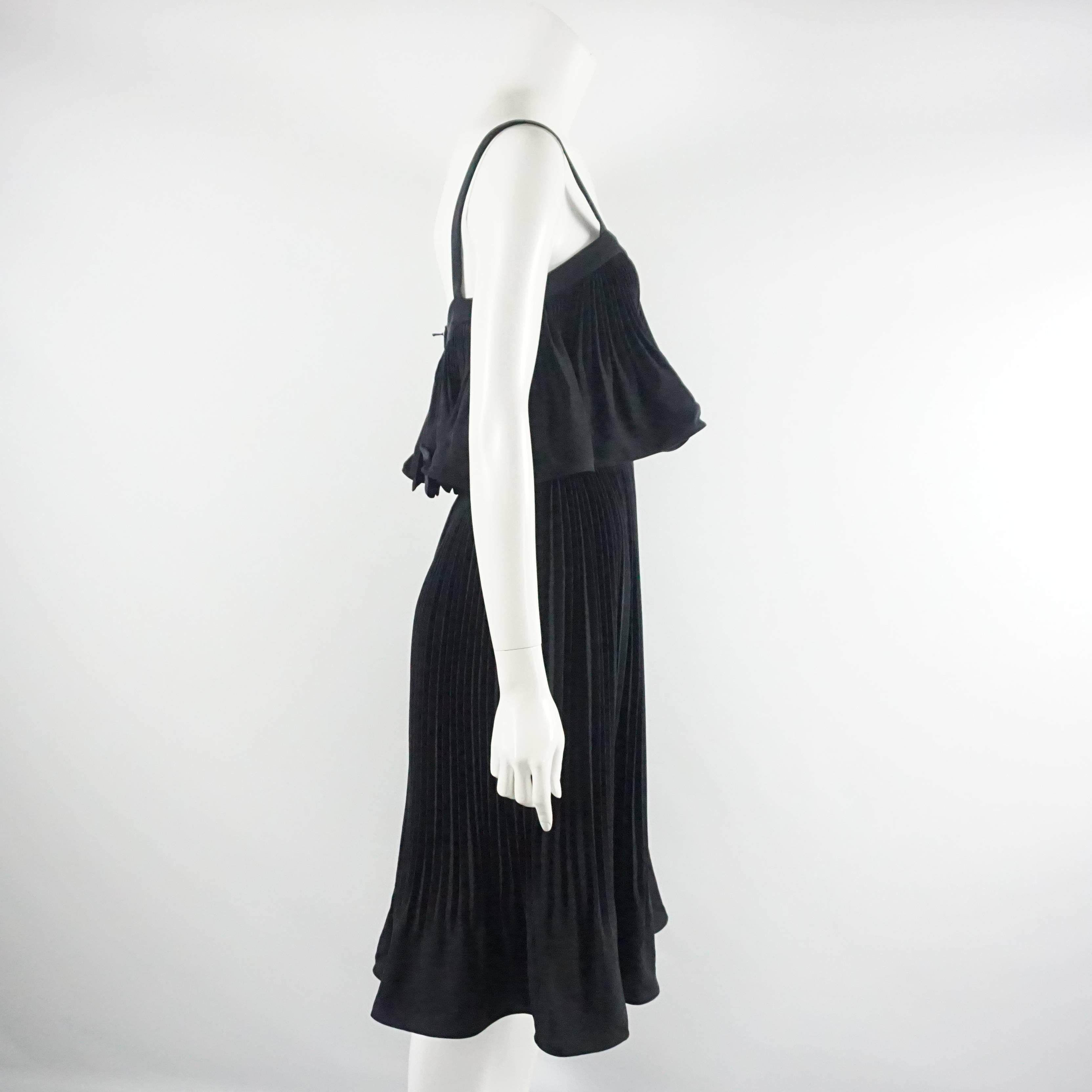 This gorgeous Nina Ricci haute couture dress is made of silk and is entirely pleated. It has thin straps and a ruffle flounce over the bust. The piece is in excellent condition with minimal wear. Size 4, 1986. 

Measurements
Bust: 35