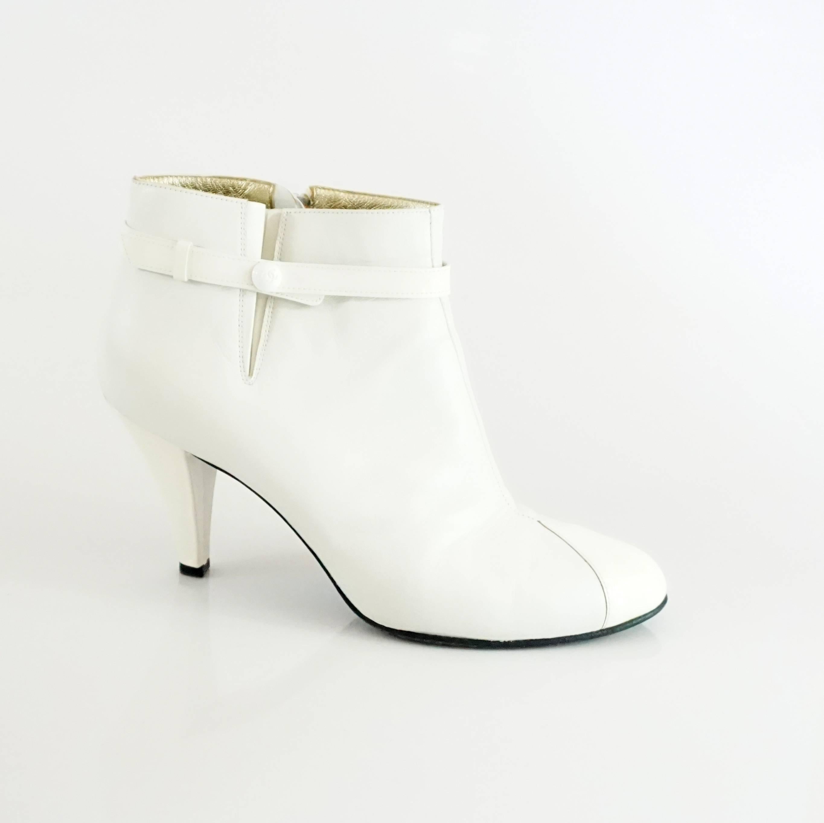 These Chanel white lambskin and patent leather booties are a modern staple. They have a side fold, ankle strap with 