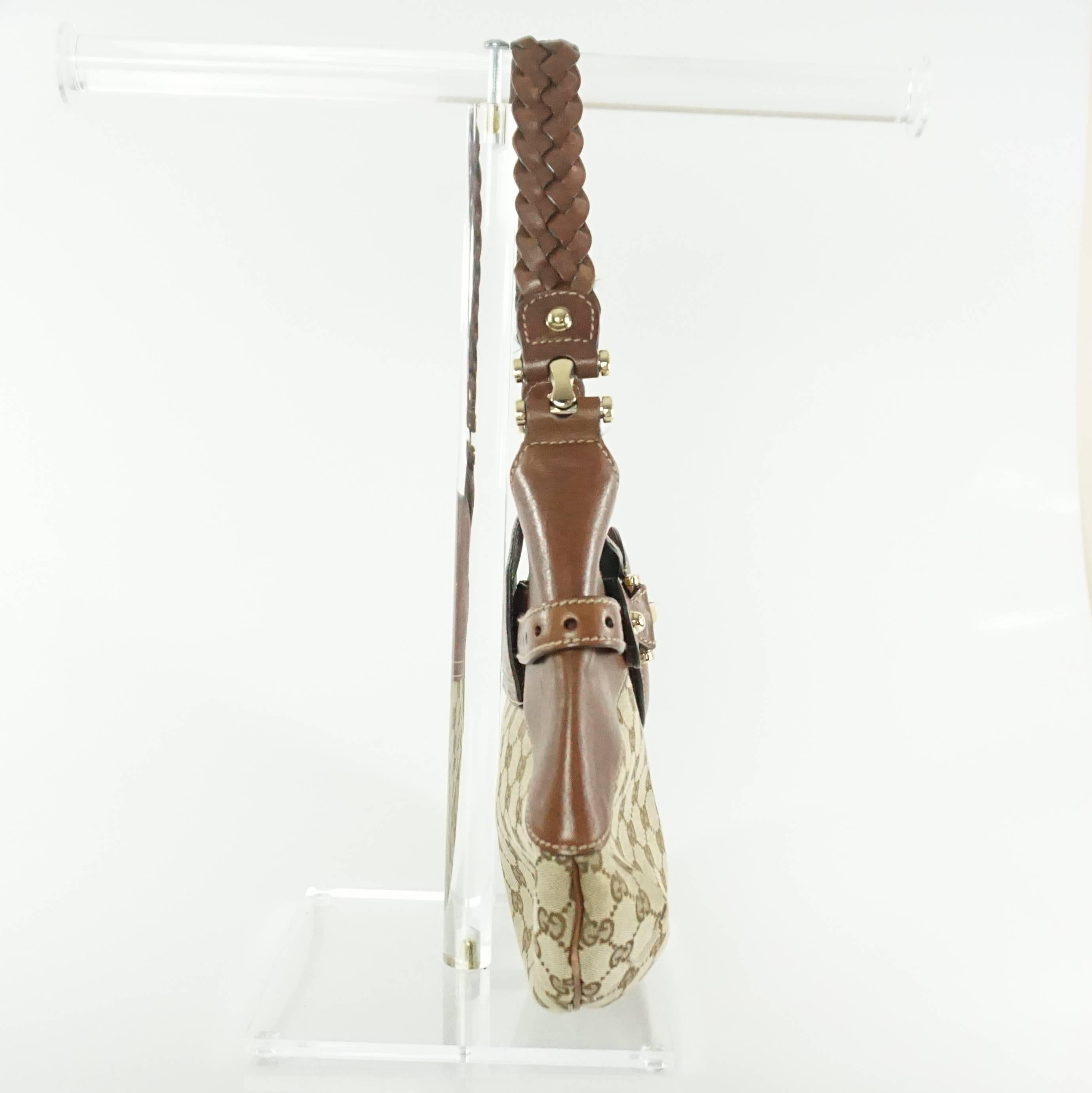 This Gucci Gg horsebit shoulder bag is made of a monogram canvas fabric with brown leather. The shoulder bag has a large horsebit detail in the front with a braided strap. The bag has a small flap and one small zipper compartment. The bag is in good