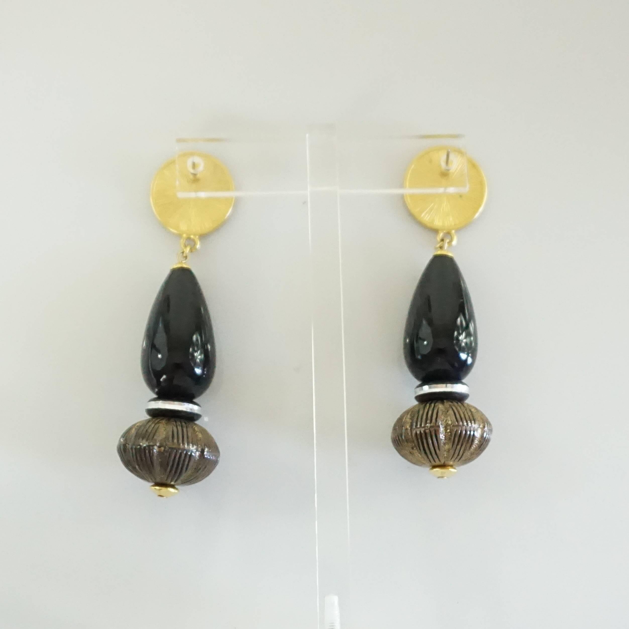 These beautiful Masha Archer drop earrings have a gold coin-like center with a black drop bead, a small black bead, and a Lucite bead in taupe. The center piece has Masha Archer and San Francisco embossed on it. These earrings are in excellent