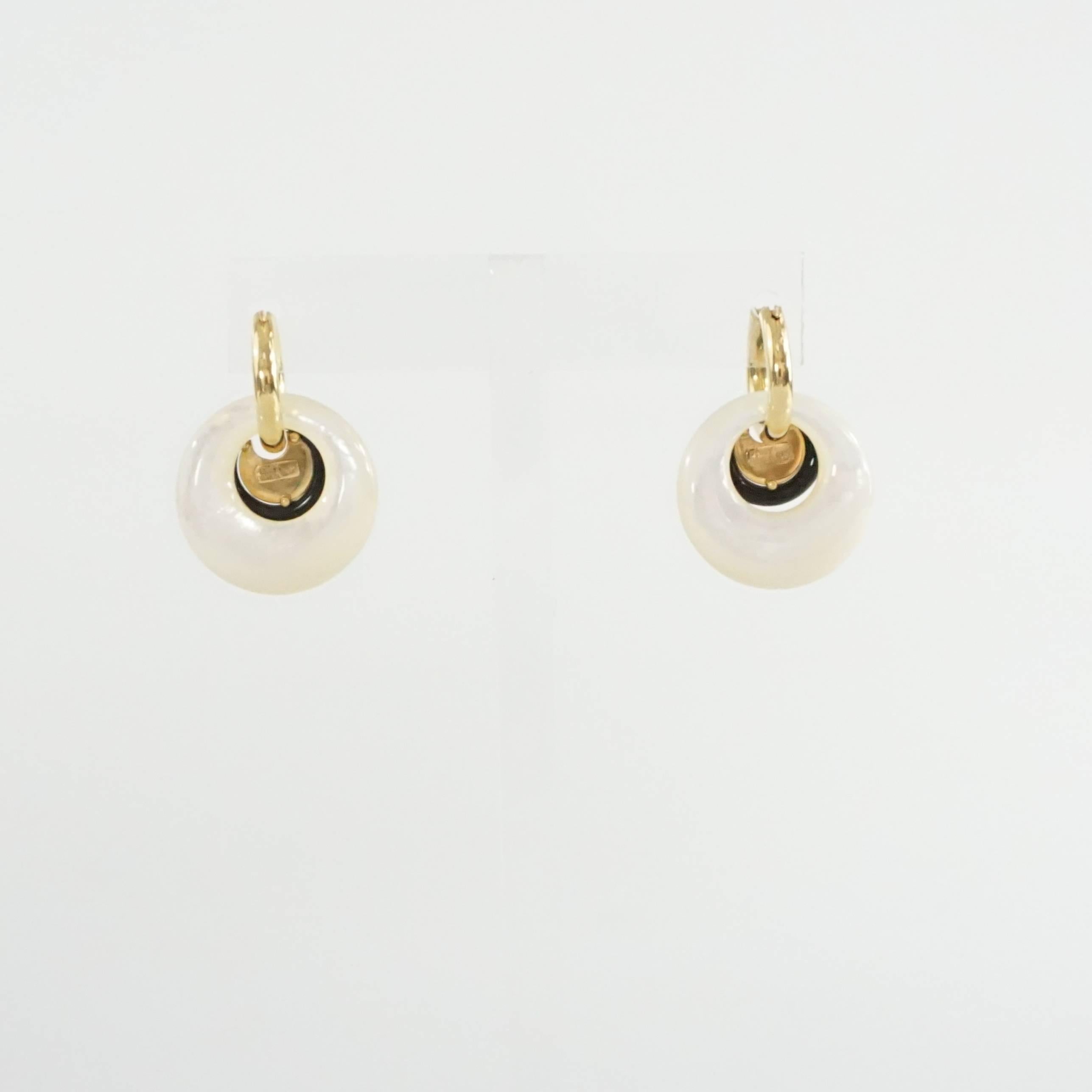 These Peggy Daven 18K gold earring hoops have 2 removable charms on. One is a mother of pearl hoop and the other is a small ebony and diamond circle. The earrings are in excellent condition.

Hoop Drop: 1.25