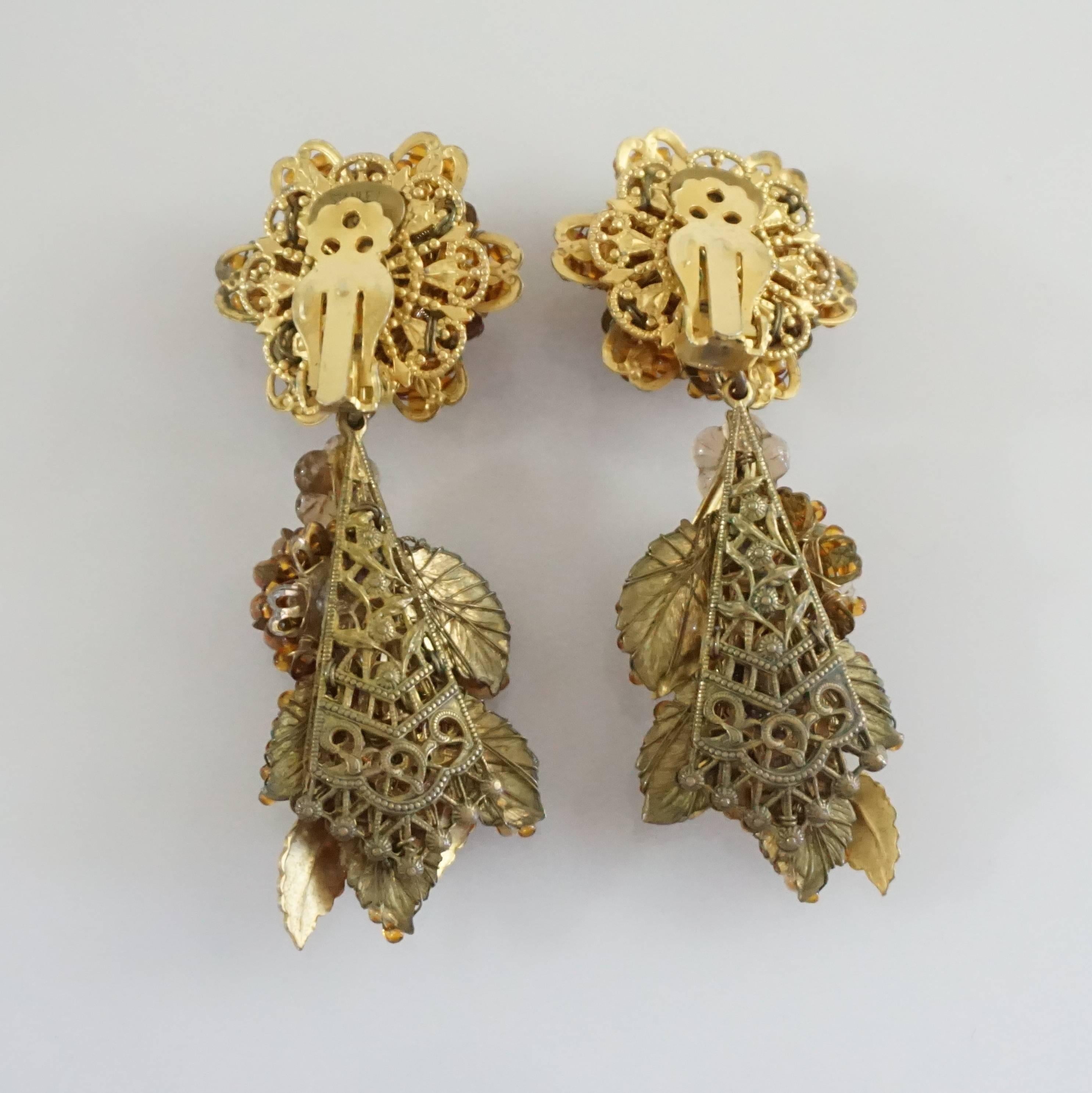 These Stanley Hagler drop earrings are beads in an amber color. They have a floral and leaf design and a clip-on back. These earrings are in very good condition with some wear on the leaves and clip.

Measurements
Width: 1.25