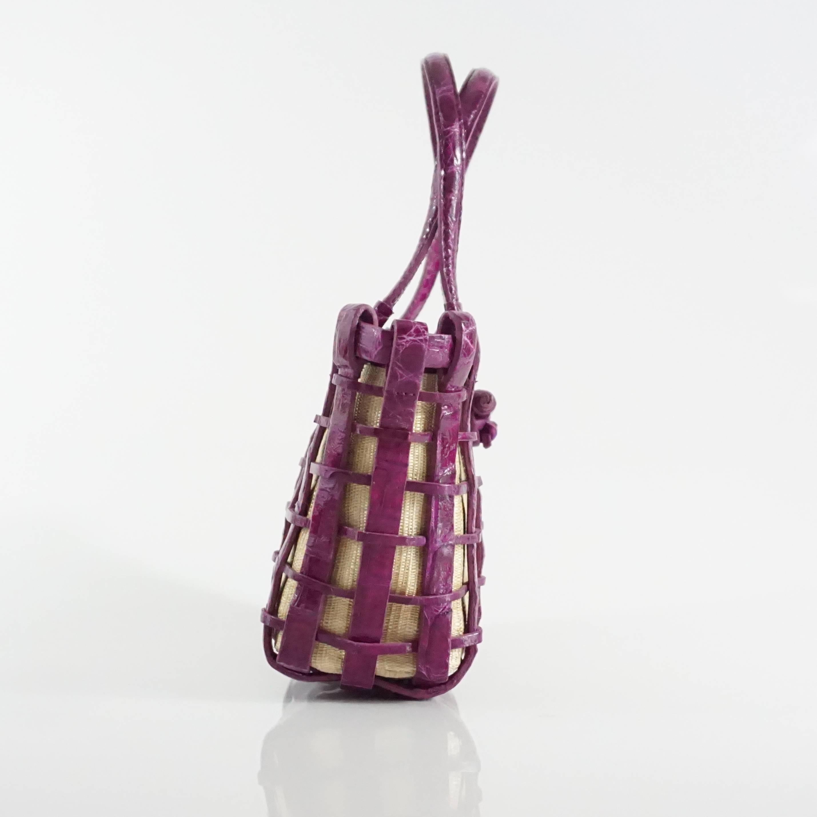 This Nancy Gonzalez fuchsia crocodile skin and canvas mini tote has two handles and a woven appearance. The inside is purple and has a zippered pocket. This mini tote is in excellent condition and comes with a duster.

Measurements
Height: 5