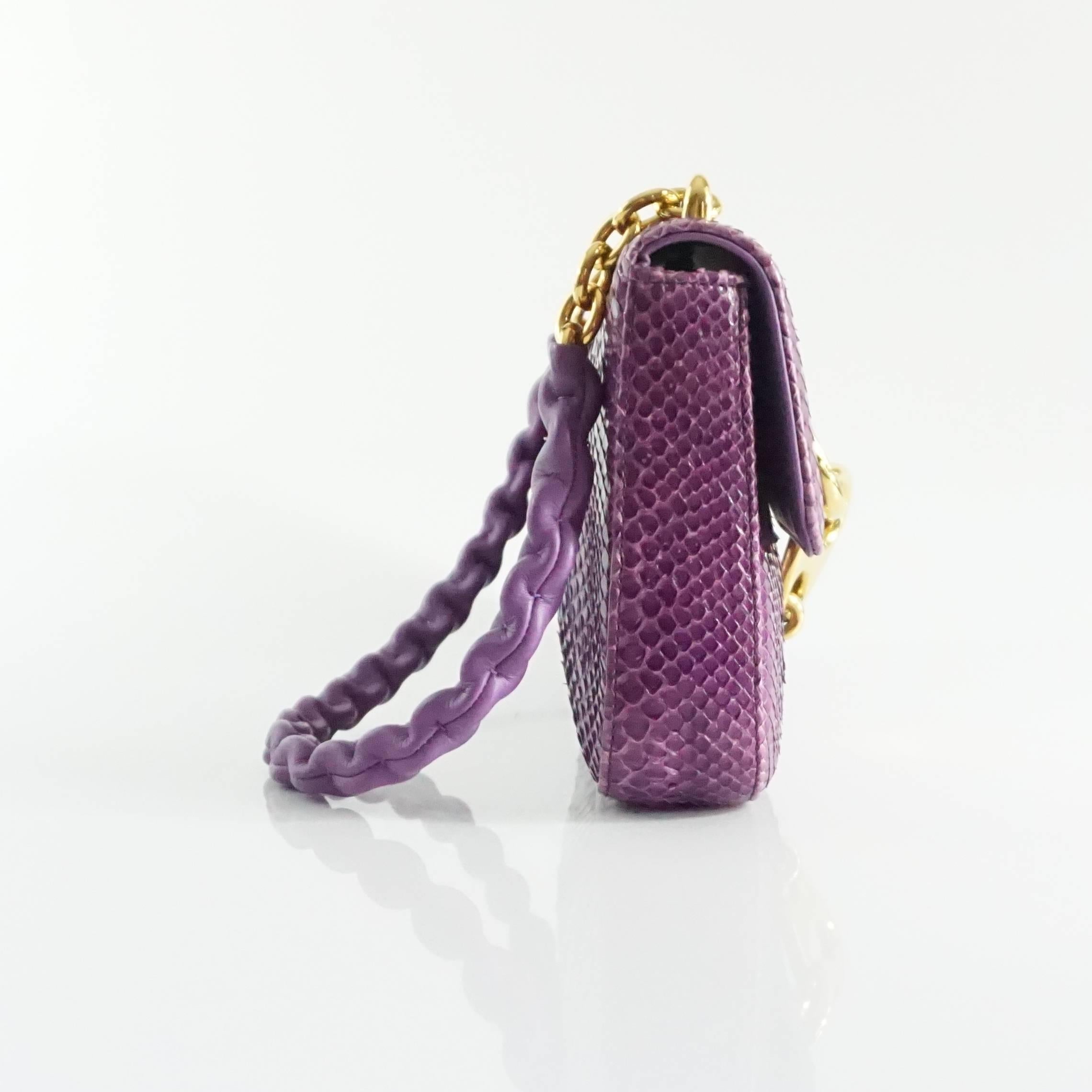 This Tom Ford purple python bag has a large link closure and gold chain strap with leather overlay. The bag is a flap style with purple leather lining and one zip pocket. The bag is in excellent condition with very minor raising of the scales that