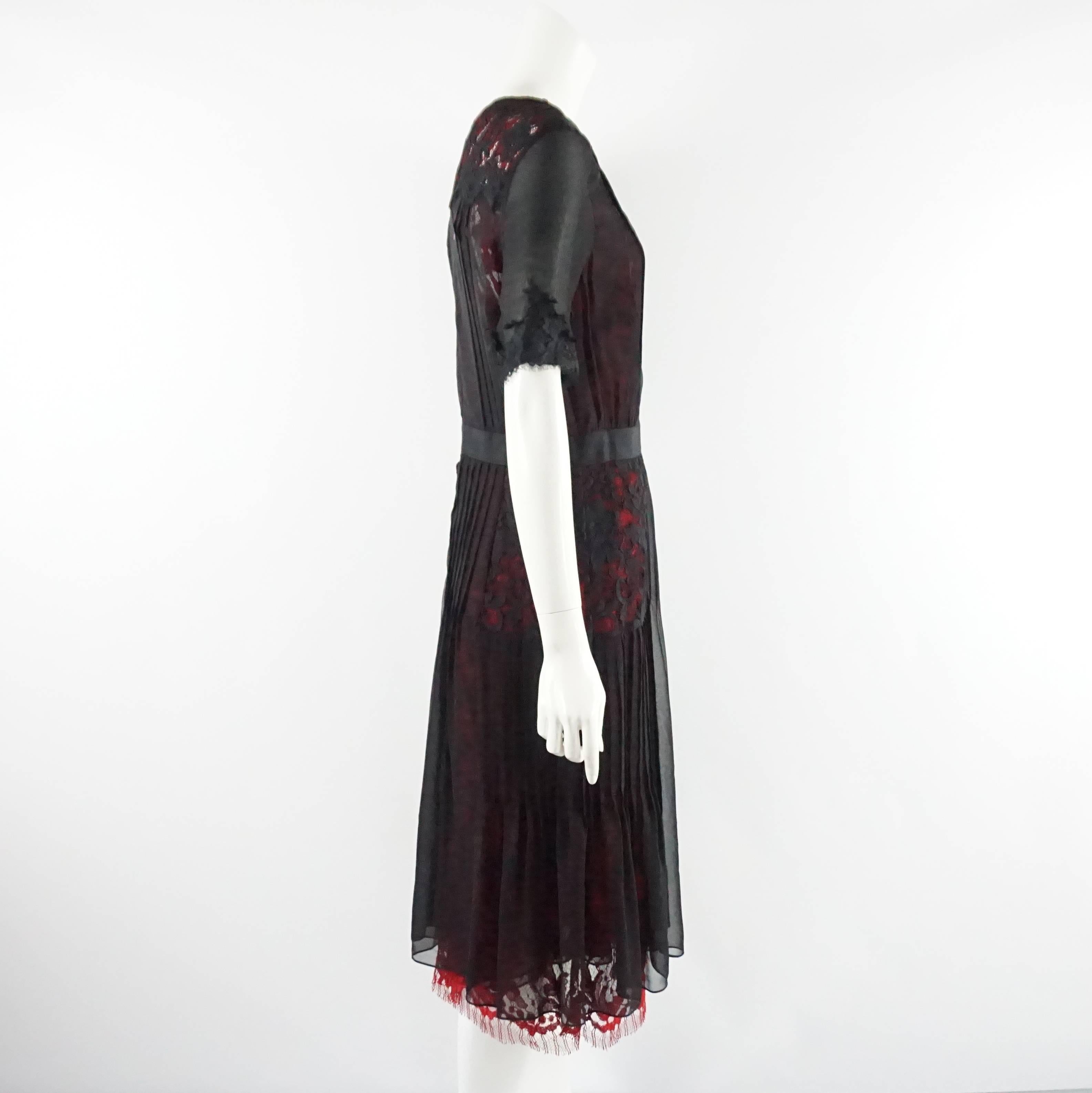This Oscar de la Renta dress is black with a red underlay. It is made of silk chiffon and lace and has a black ribbon around the waist. This dress is in excellent condition and still has a tag. 

Measurements
Shoulder to Shoulder: 15