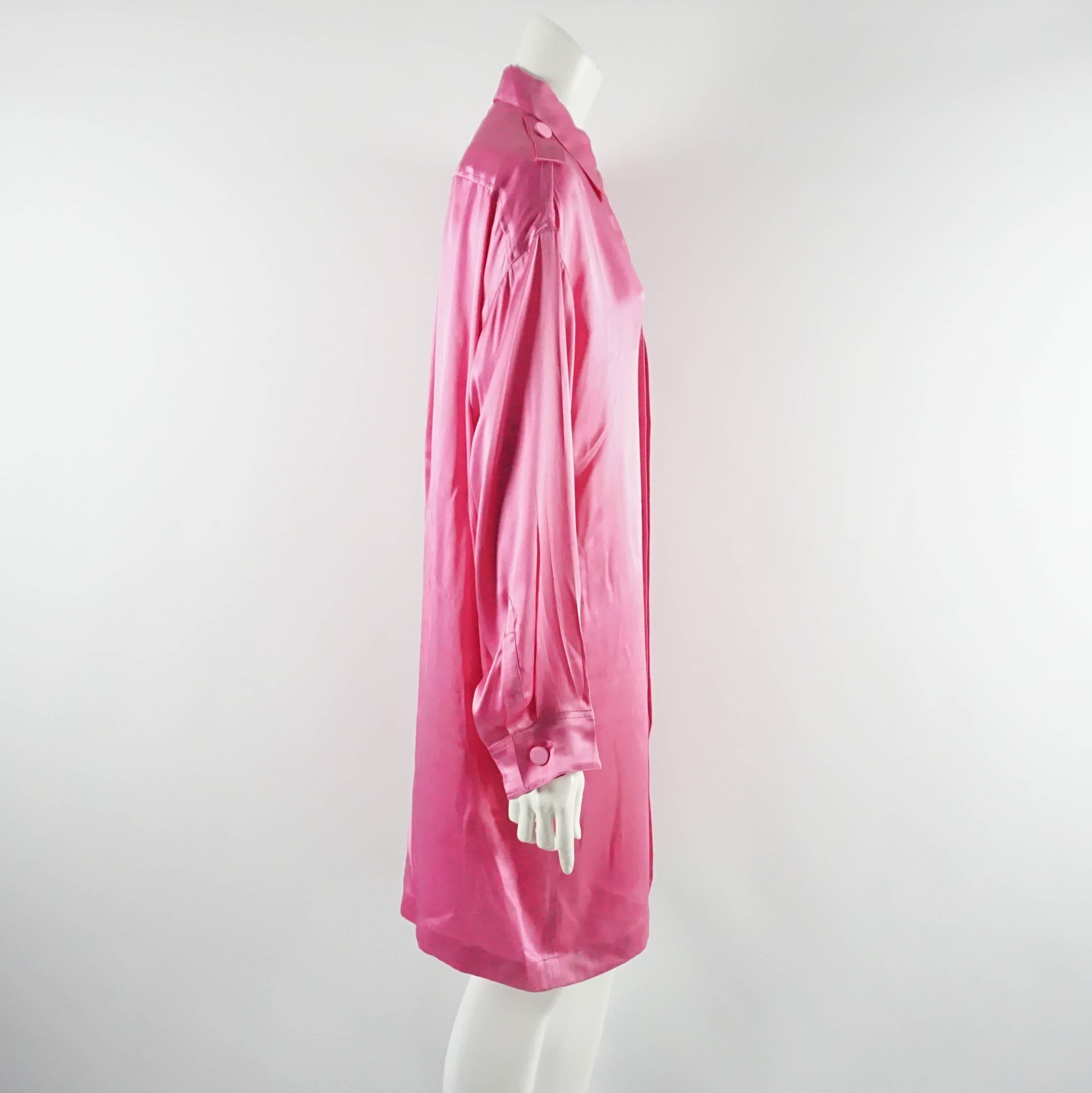 Este divertido vestido camisero de seda Lanvin es de color rosa intenso. Tiene cuello, bolsillo delantero, mangas largas y adornos a presión en los hombros. Este vestido está en buen estado, con algunas manchas como se ve en las últimas imágenes.