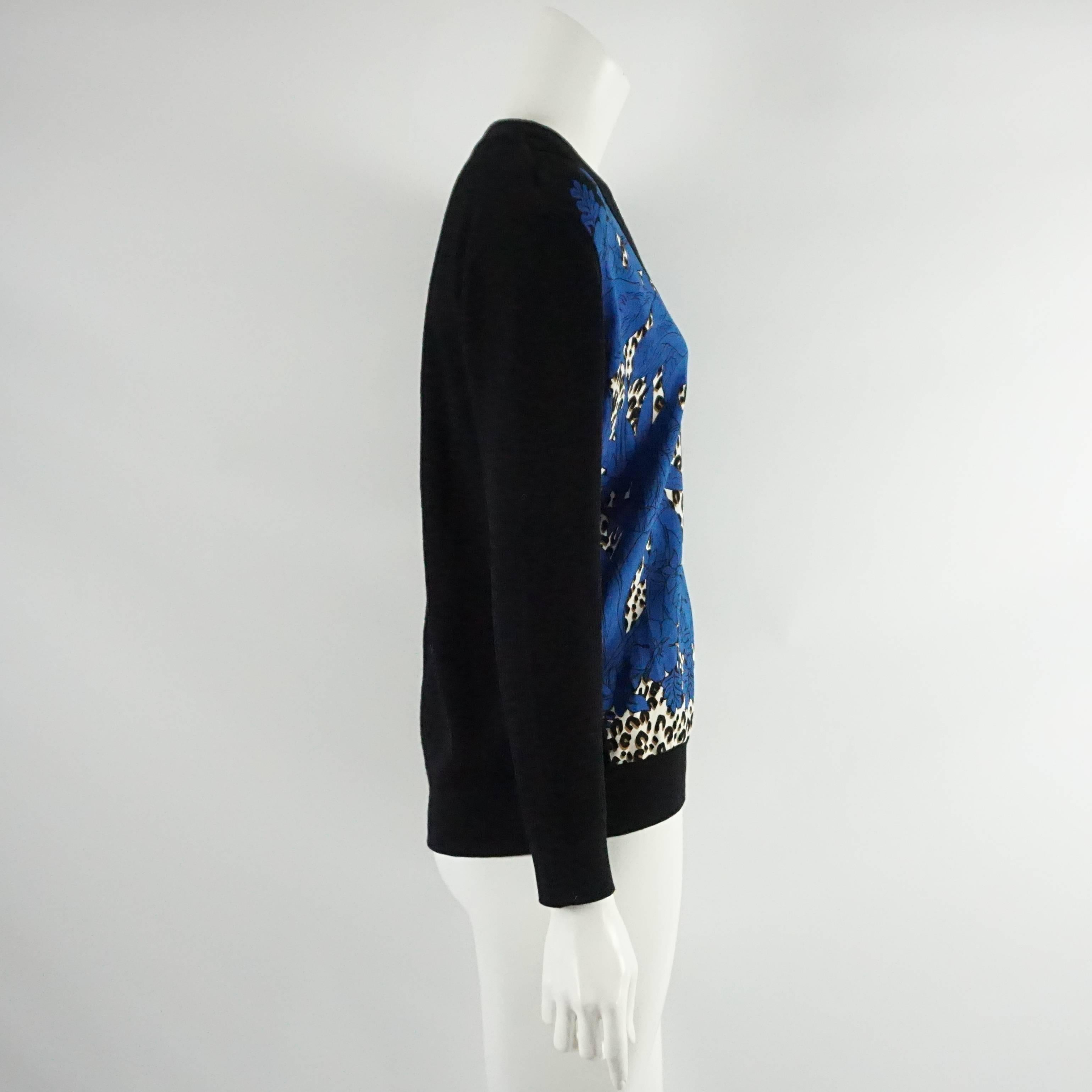 This beautiful Louis Vuitton cardigan is black wool with a blue silk front. The front has a floral and animal print design, black buttons, and a v-neckline. This cardigan is in excellent condition.

Measurements
Shoulder to Shoulder: 18"
Sleeve