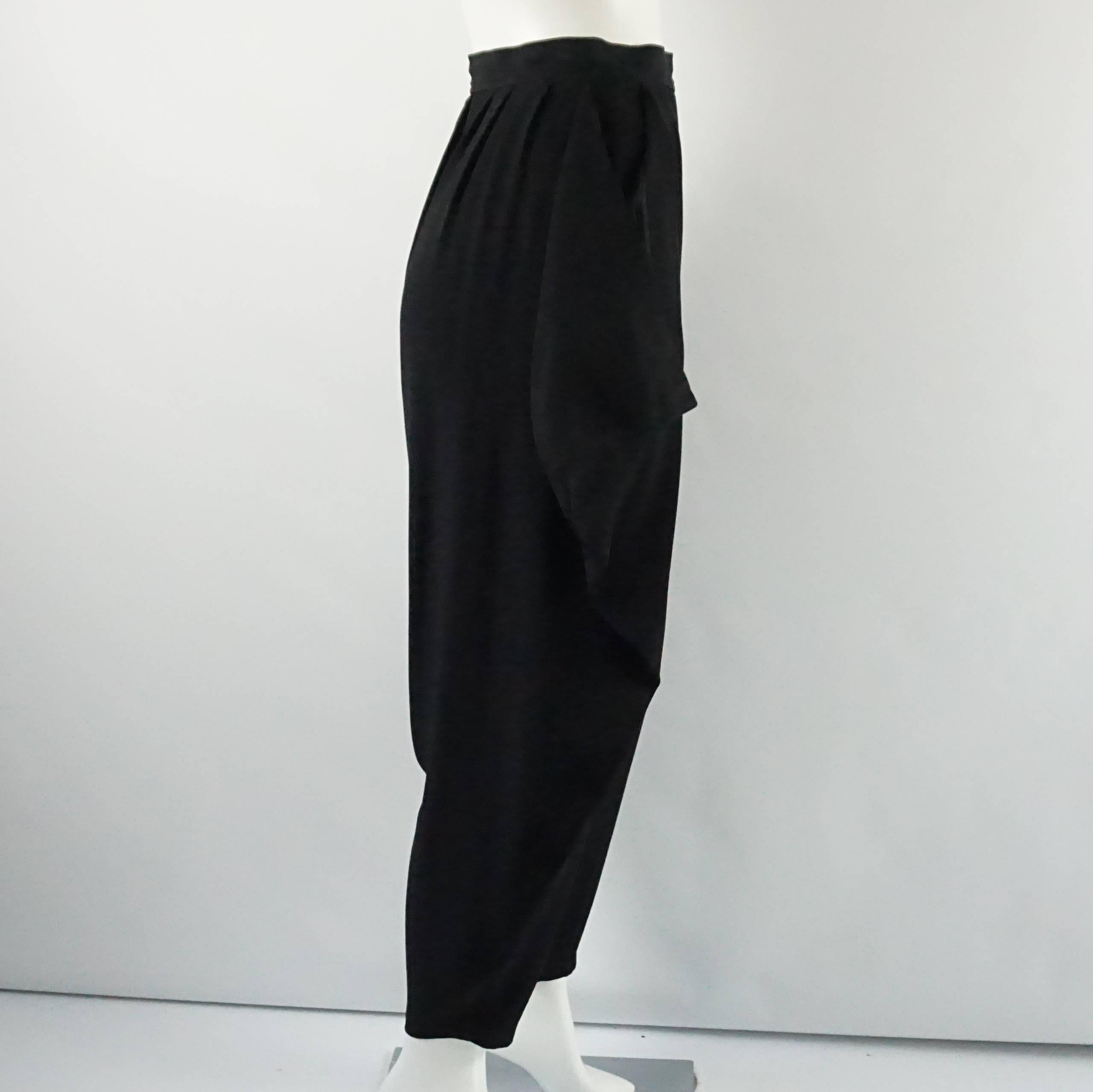 These YSL black pants are made of wool. They are high waisted and are a harem style with ruched fabric along the sides. The pants are in excellent vintage condition with very minor general wear to the fabric. Size S, circa 1980's.