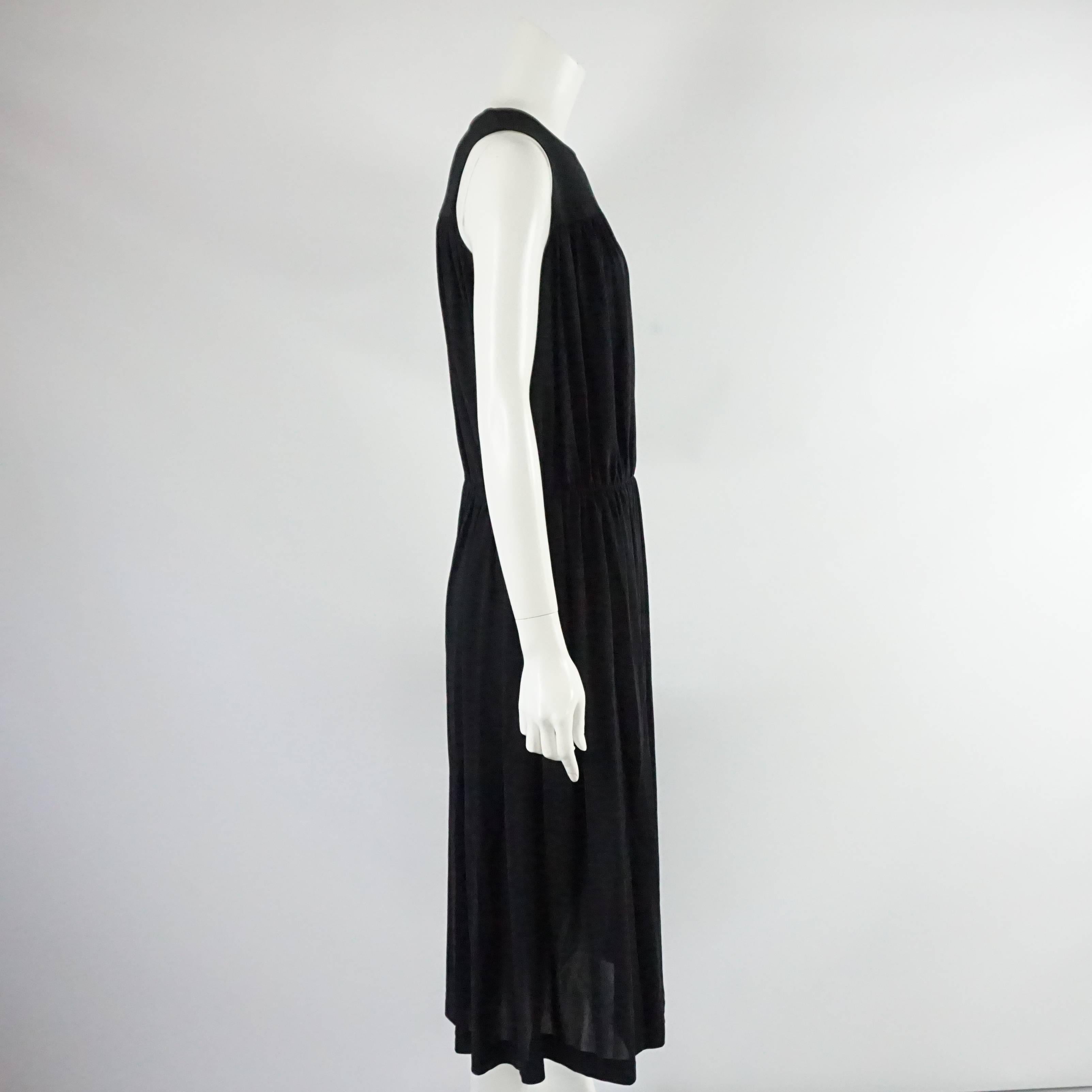 This Comme de Garcons sleeveless dress is made of black silk. It has a pleated top and bottom and is cinched at the waist. This dress is in very good condition with some minor imperfections (see last 3 pictures).

Measurements
Bust: 33