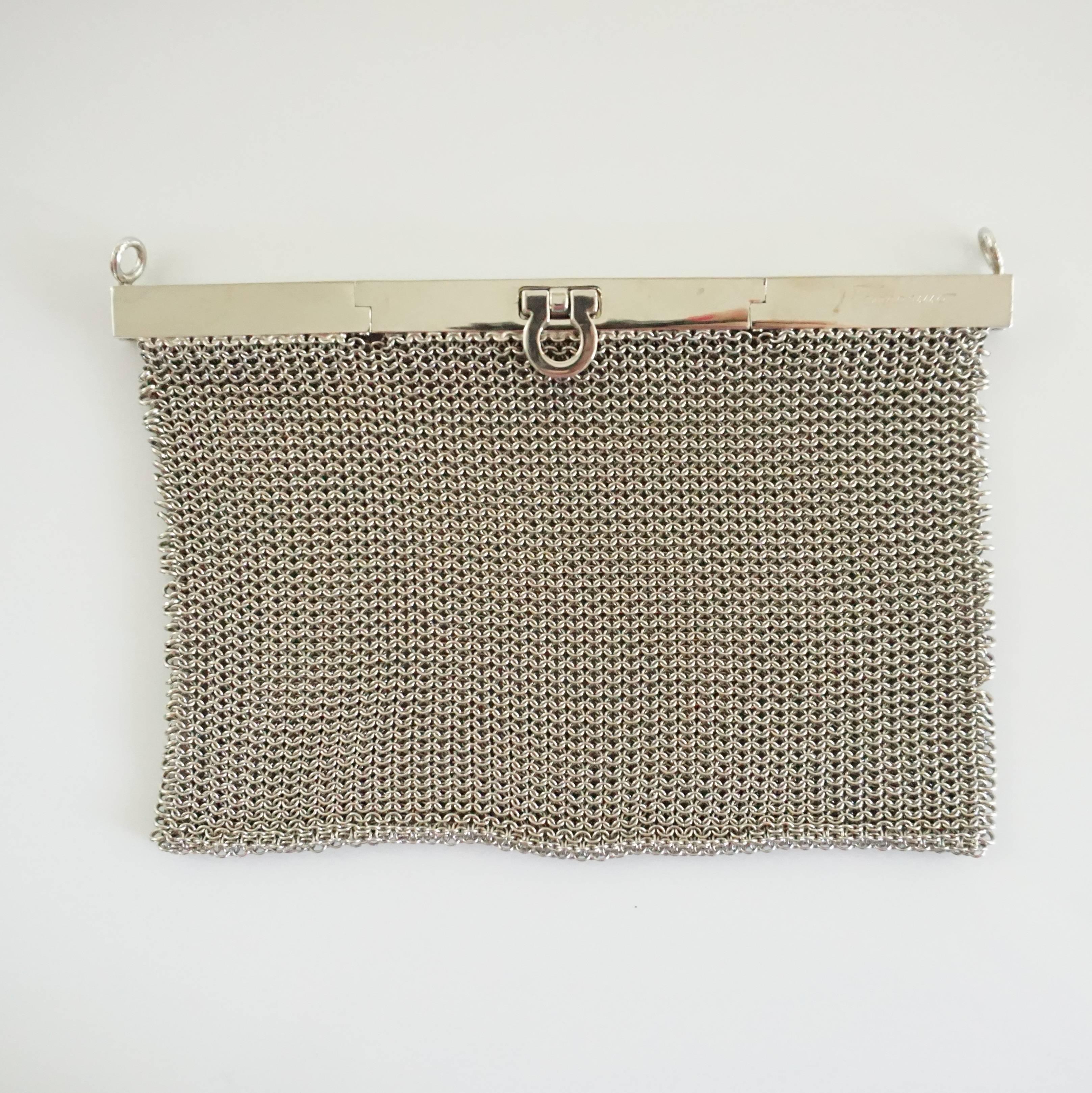 This Salvatore Ferragamo silver mesh bag is a stunning, unique piece. Its entirety is mesh with a frame top and it has a removable shoulder strap. The piece is in excellent condition with some minor wear to the frame. Circa 21st