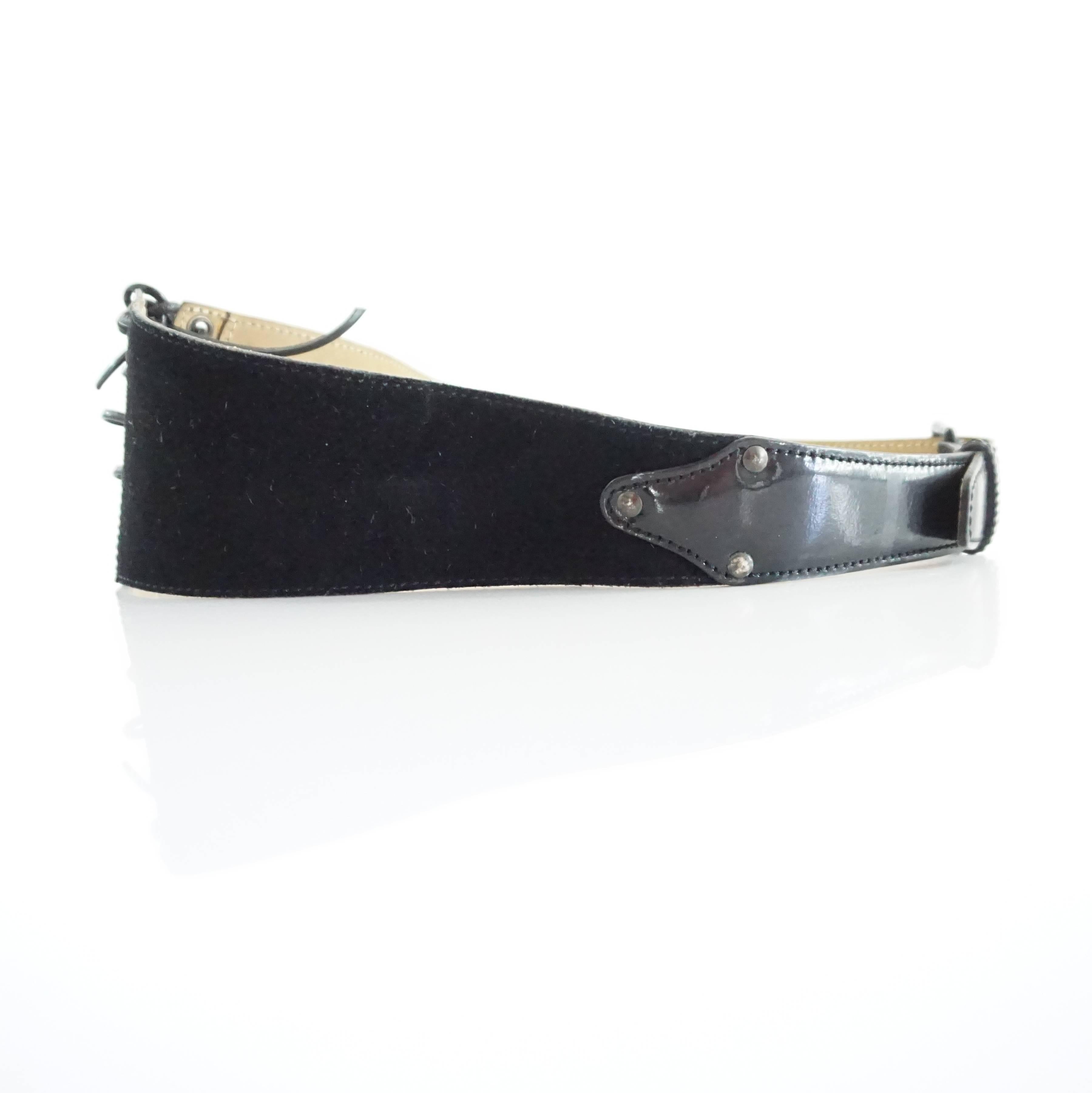 This Alaia belt is suede with a patent leather front. It has a angular look and lace-up front closure. The piece is in fair condition with some wear to the laces, belt strap, and interior as seen in the images. Additionally the belt looks somewhat