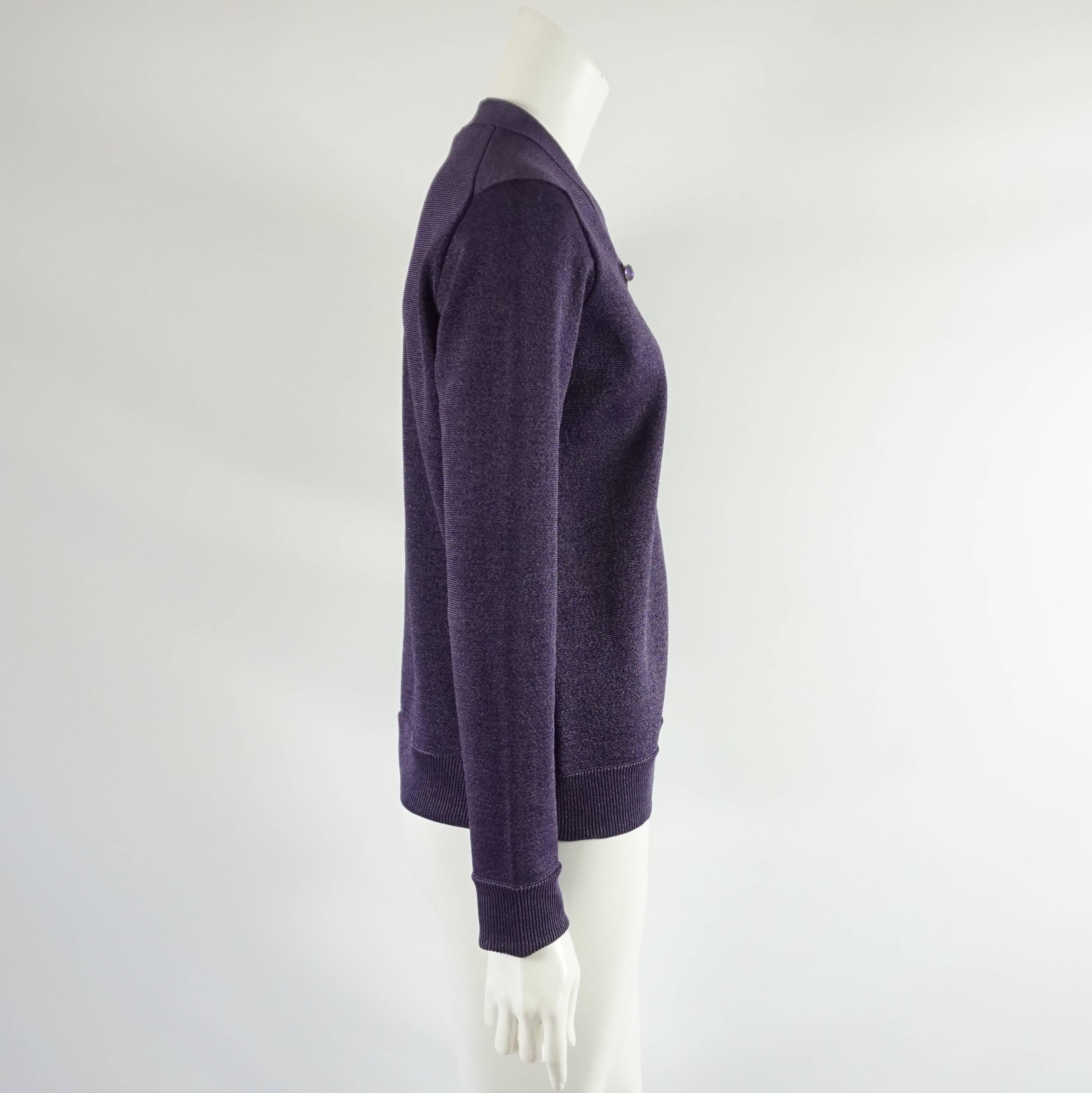 This Louis Vuitton cardigan is metallic purple. There are buttons going down the front that are large purple rhinestones. This cardigan is in excellent condition.

Measurements
Shoulder to Shoulder: 16