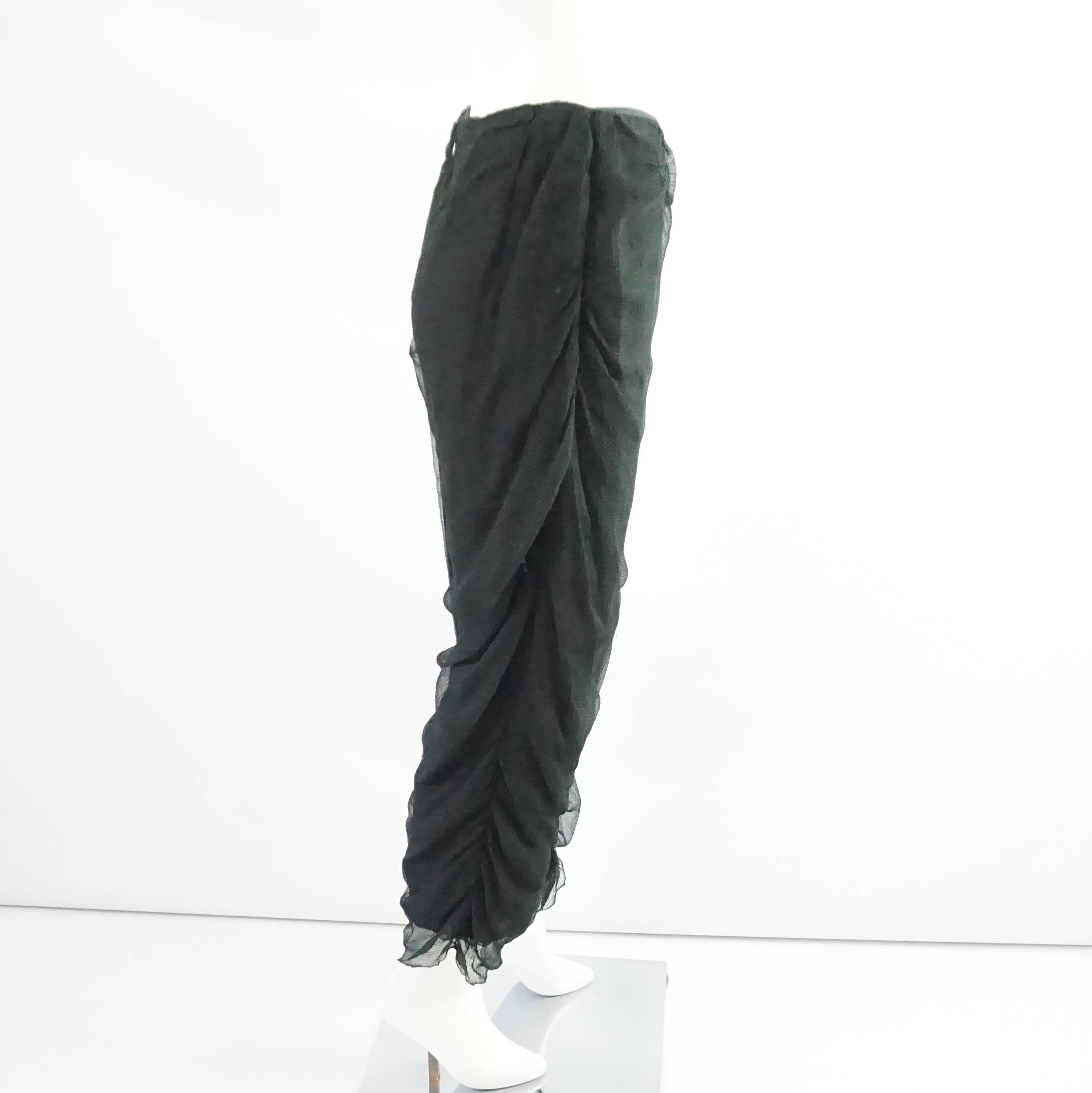 These Chado pants are black and made of silk chiffon. They are lightweight, textured, and slightly sheer. The bottoms of the legs have cinched fabric. These pants are in very good condition with some overall pulled fabric. Size