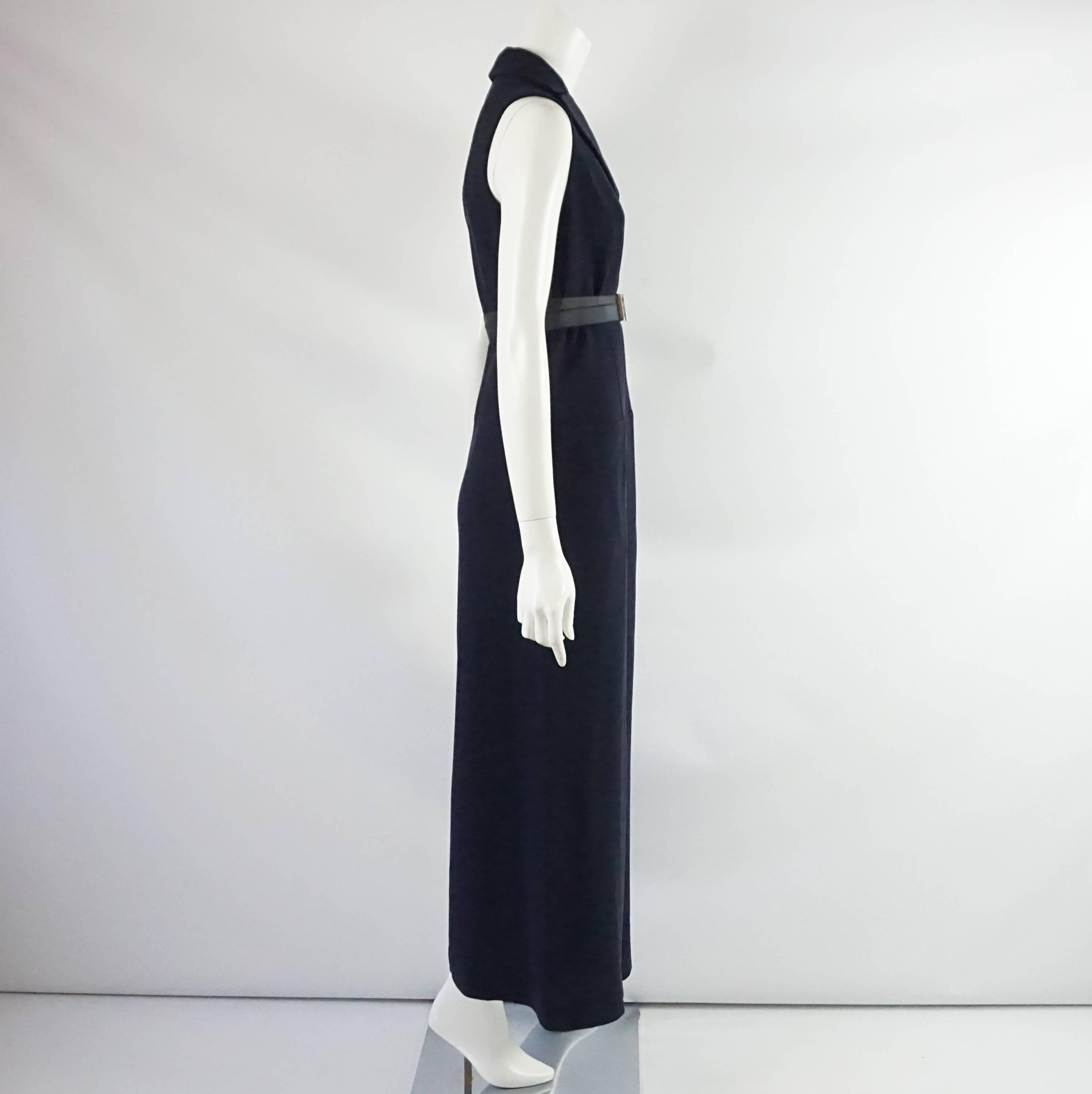 This Dior palazzo pant jumpsuit is navy silk with a v-neck and collar. It has concealed buttons on the front and a zipper. There are belt loops and a belt and 2 front pockets. The belt has an acrylic and silver closure. This jumpsuit is in excellent