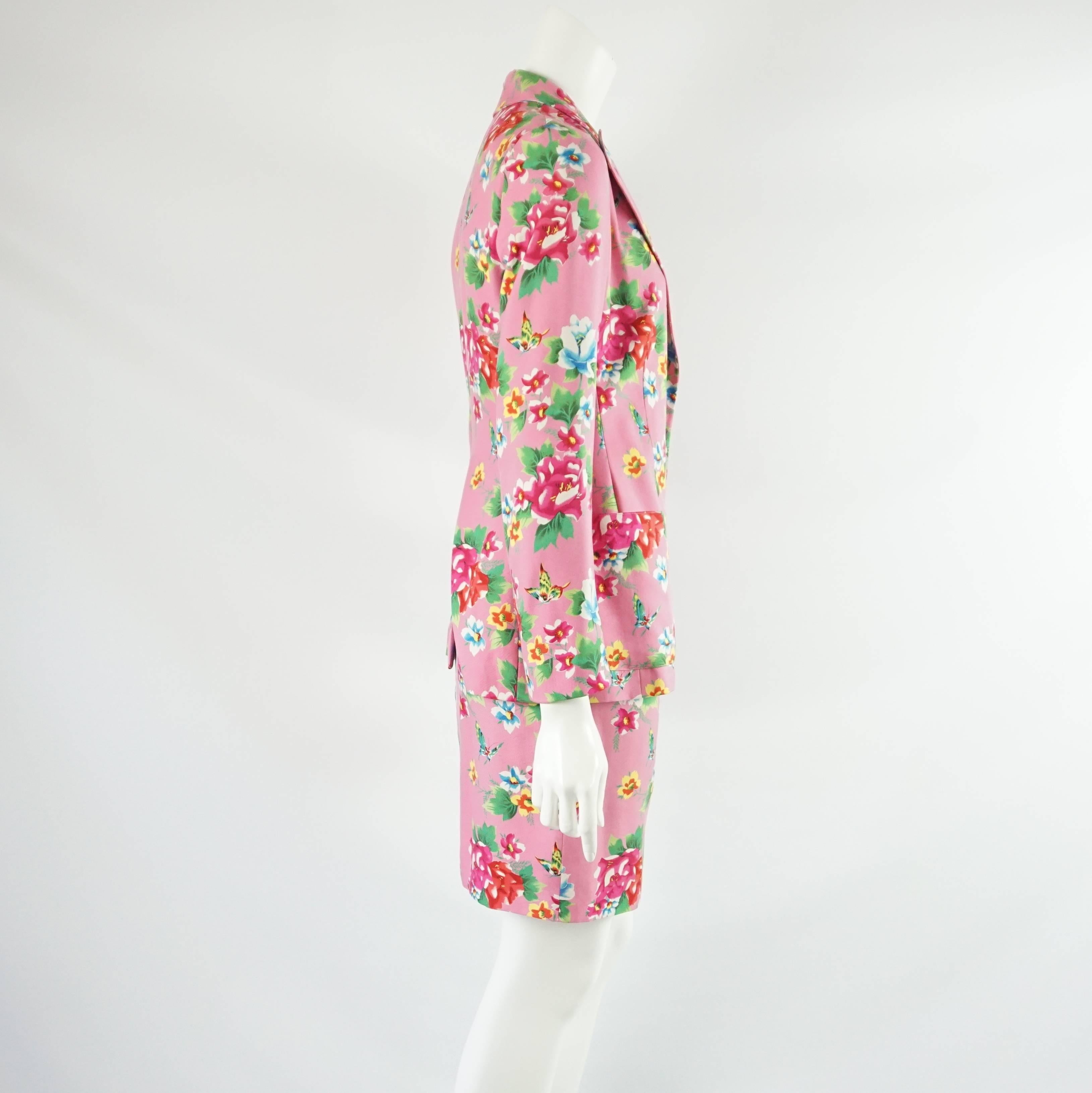 This Todd Oldham pink silk skirt suit has a multi-color floral print. The jacket is single breasted with 3 front pockets and 2 front buttons. The skirt has a straight cut and is high waisted. Both pieces are in very good vintage condition with a