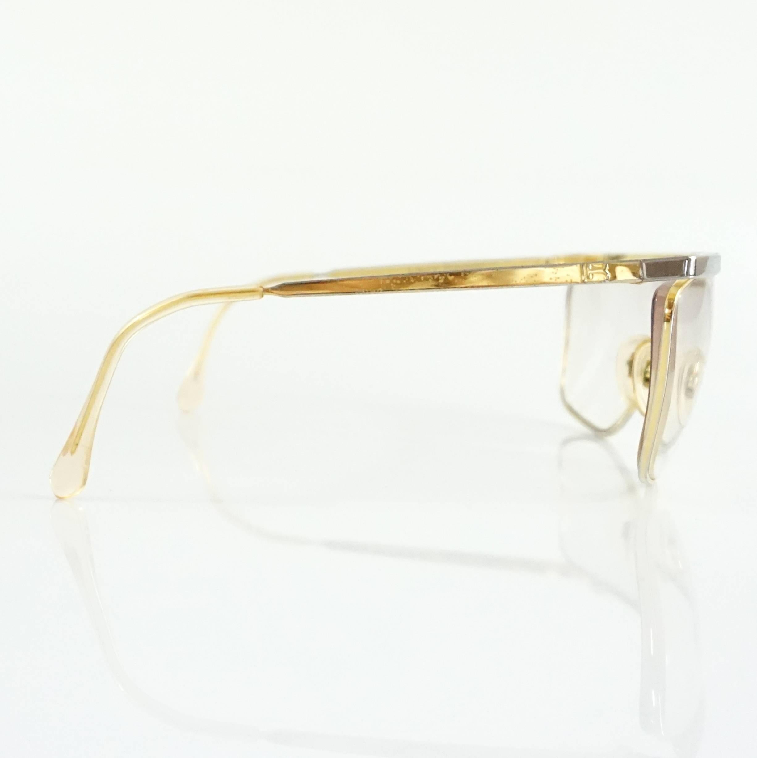 These Laura Biagiotti glasses are gold and silver. They are in fair condition and have overall wear.

Measurements
Length: 6.8"
Leg Length: 4.5"
Lens Length: 2.5"
Lens Height: 2"