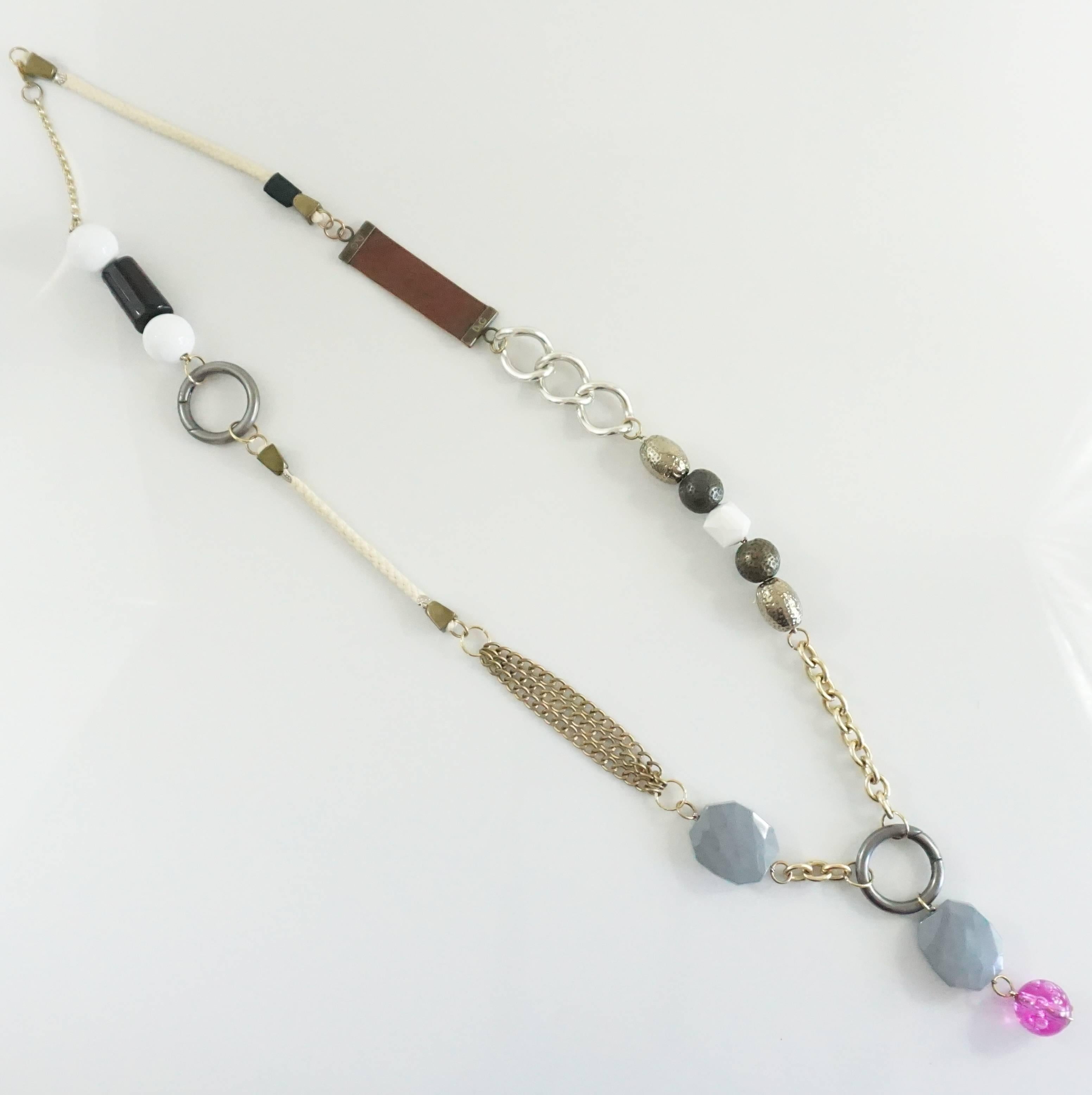This intricate D & G long necklace is comprised of different sections and different materials. There are two silver circles which can be opened and removed to change the necklace (image 3 is an example). This necklace has a leather strip with