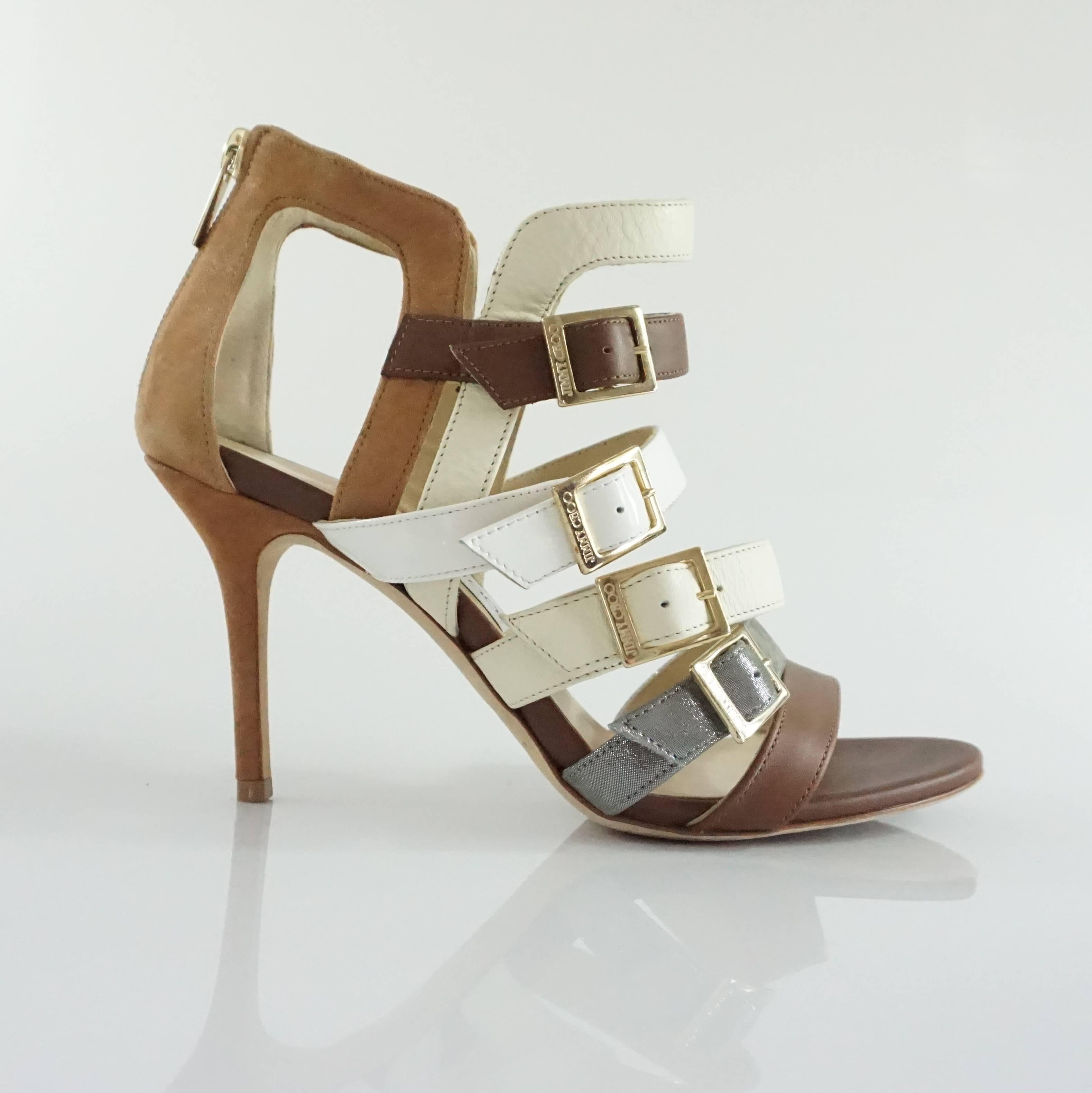 These Jimmy Choo bootie sandals have mixed fabrics (leather, patent leather, suede-like material) and are multicolored with different earthtones. There are straps of dark brown leather, white patent leather, cream leather, and a metallic silver