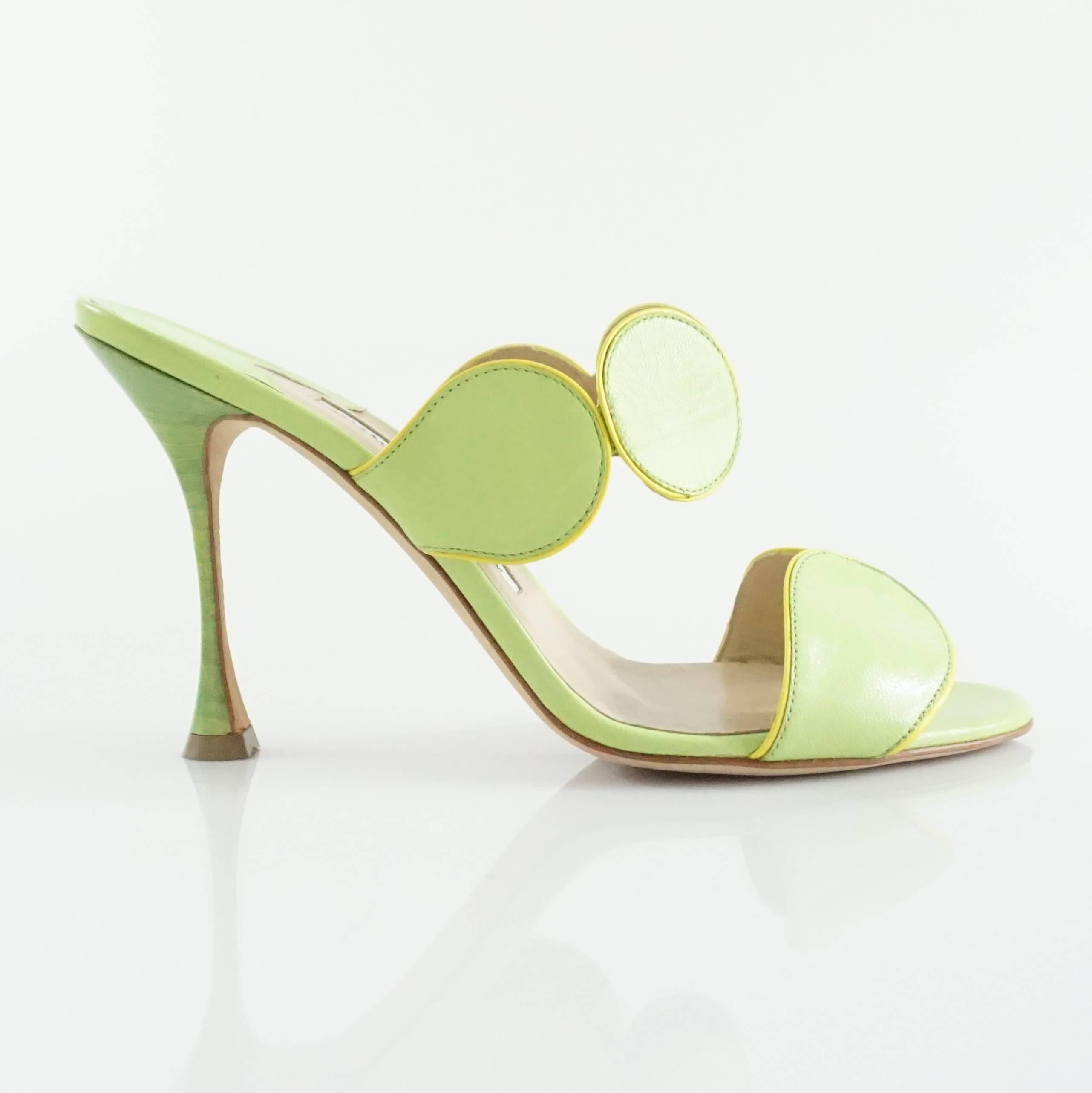 These Manolo Blahnik sandals are green leather with a yellow trim on both straps. The straps are made of circular pieces of leather. These heeled sandals are in very good condition with minor wear.

Heel Measurement: about 4"