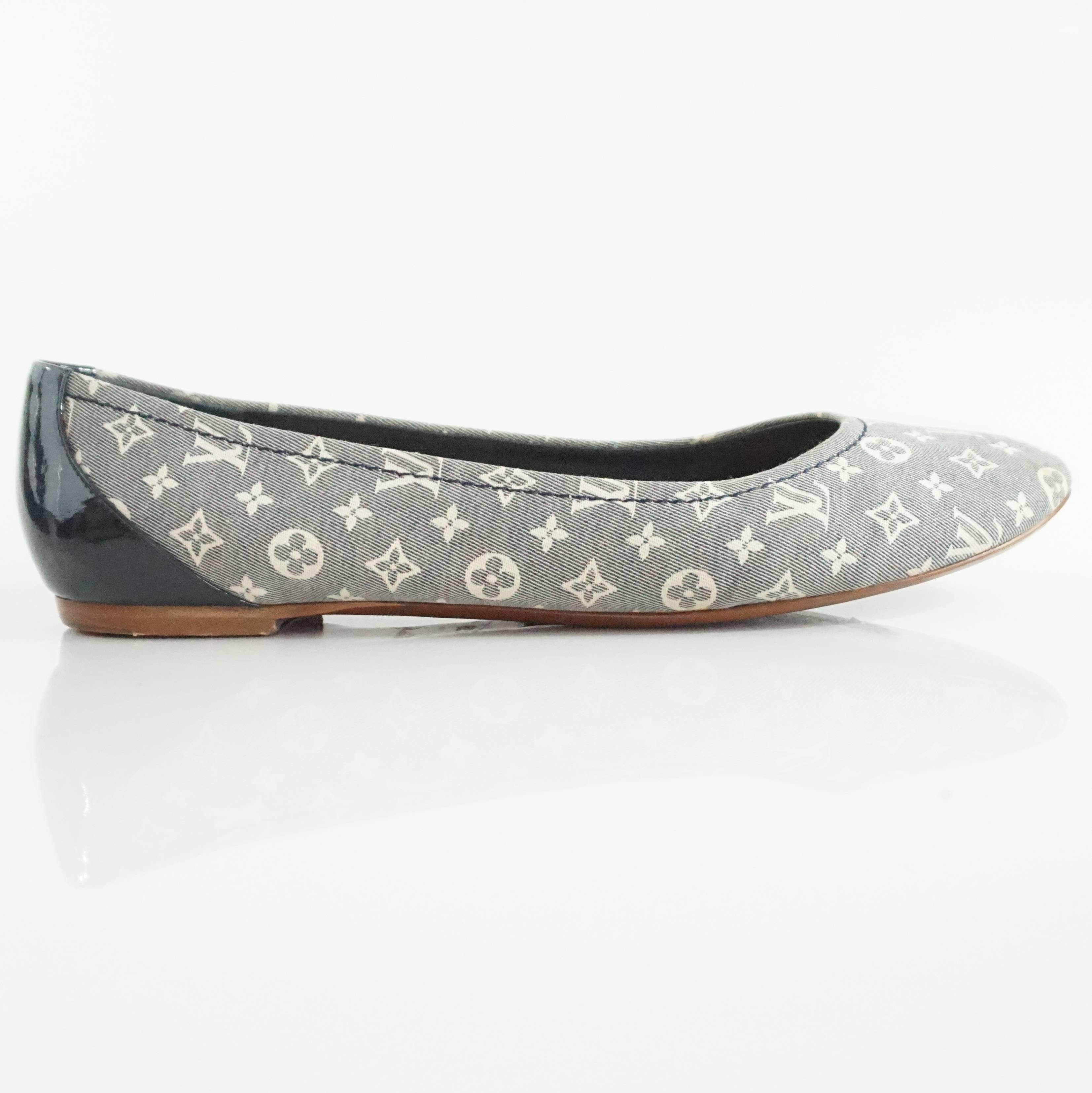 These Louis Vuitton beautiful flats are navy with an ivory monogram print. There is navy patent leather on the heels. These flats are in very good condition with minor staining and marks on the back.