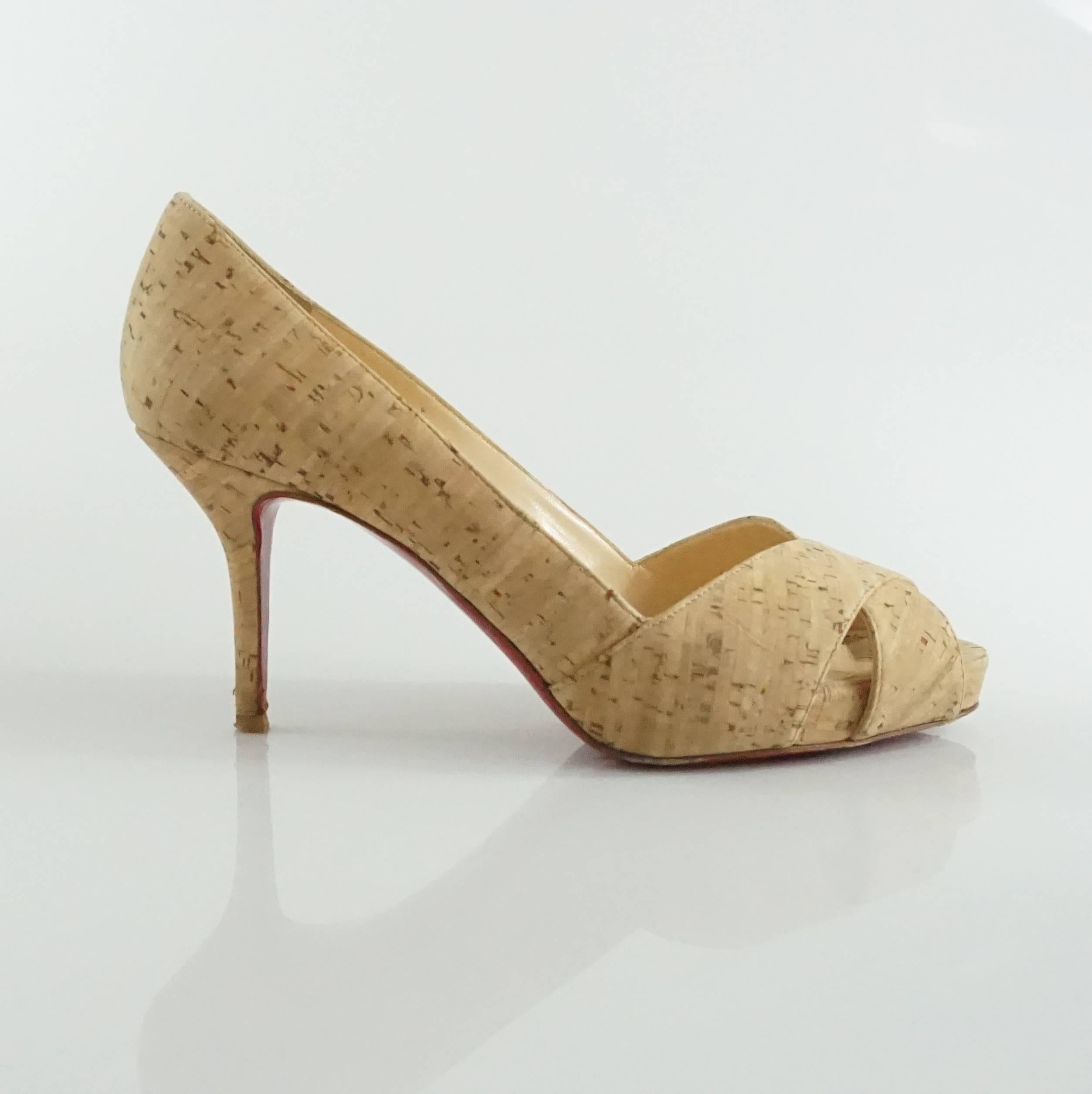 These Christian Louboutin pumps are tan with a cork print. They feature a peep-toe and the iconic red bottom. These shoes are in good condition with wear on the bottom and front.

Measurements
Heel Height: 3.25"
Platform Height: 0.88"