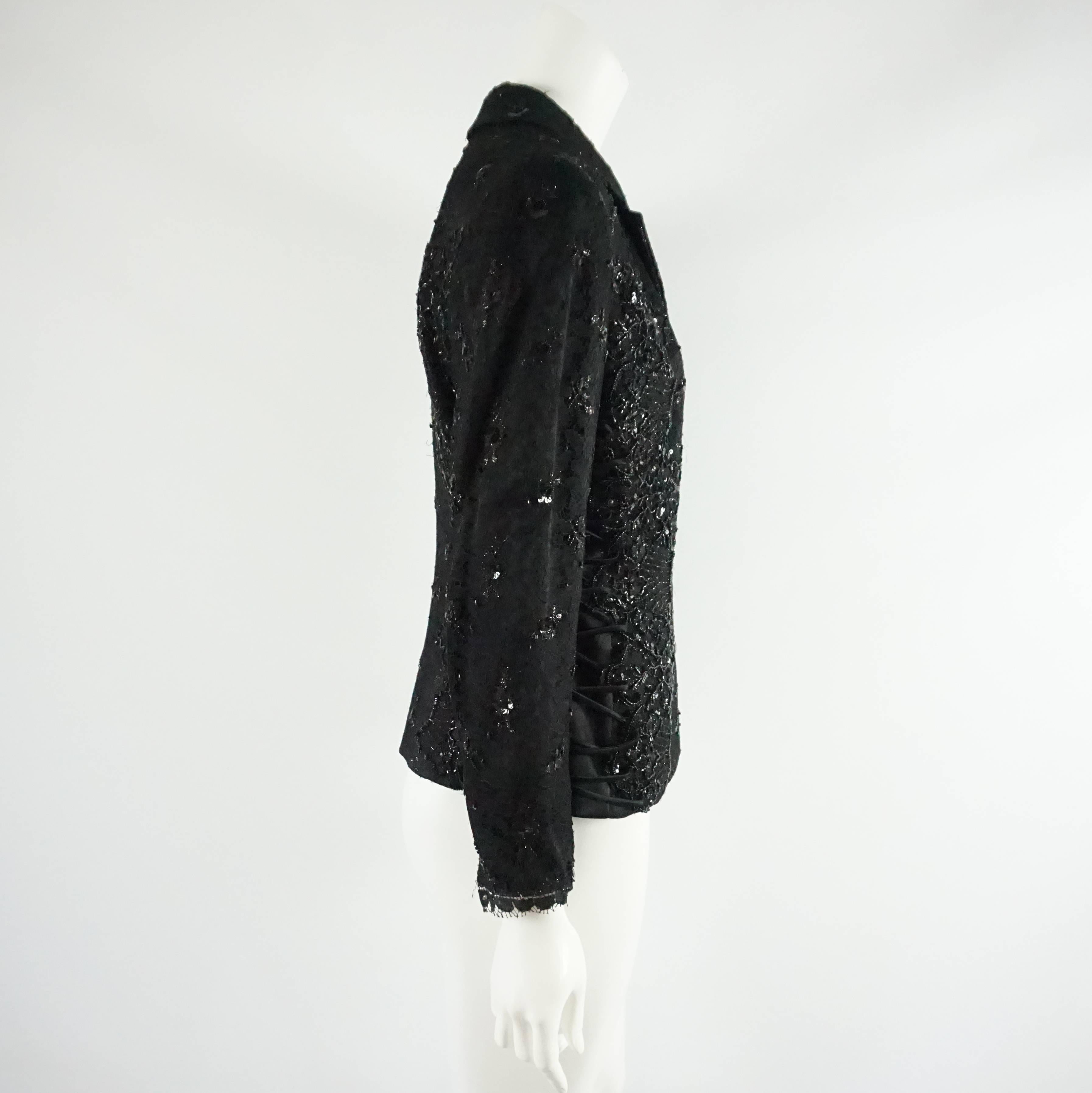 This Badgley Mischka black jacket is covered in lace and rhinestones. There is fabric that climbs up both sides and rhinestone-like buttons. This jacket is in excellent condition.

Measurements
Shoulder to Shoulder:
Sleeve