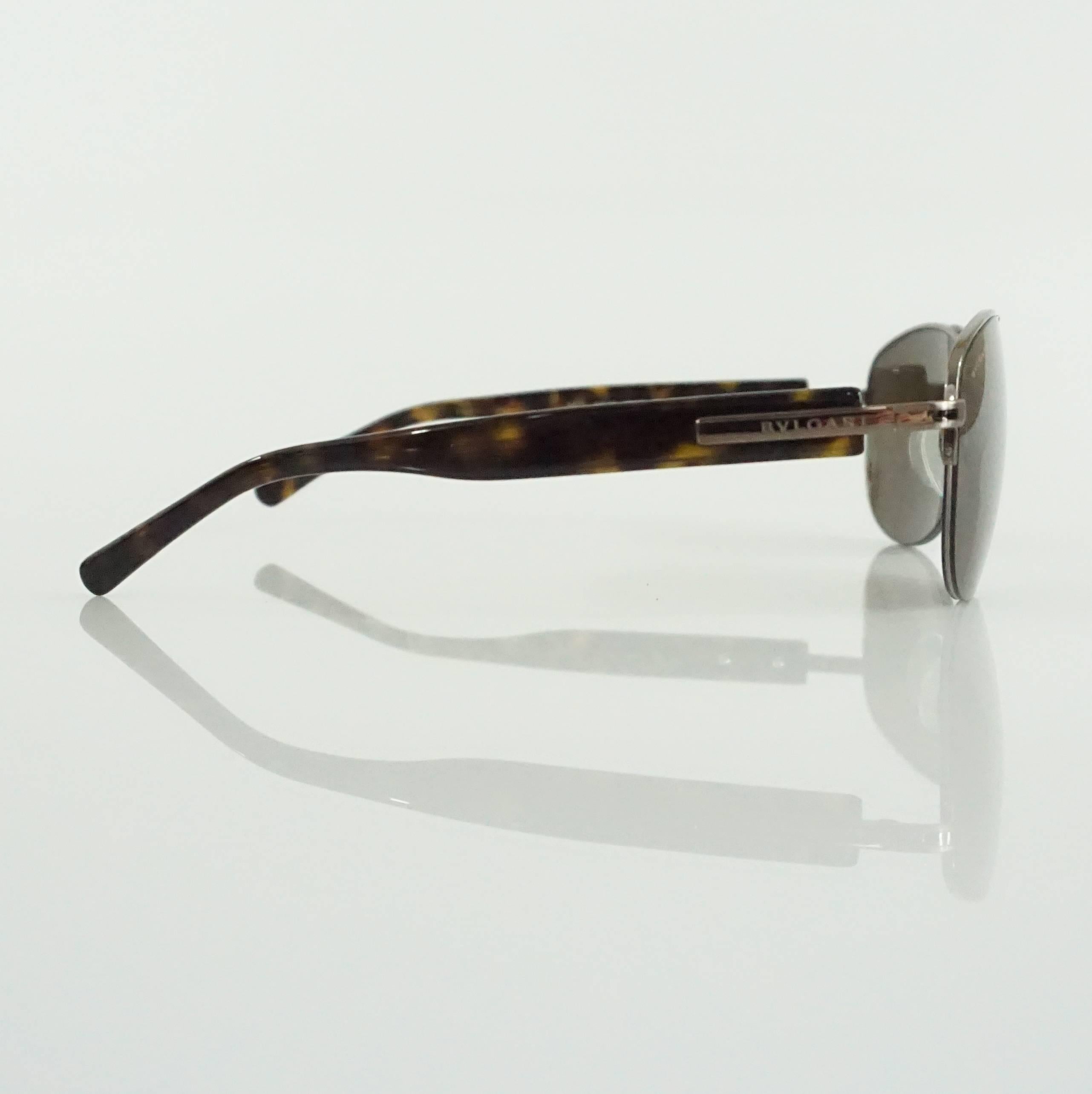 These Bvlgari aviator sunglasses feature silver detailing and tortoiseshell legs. The lenses are brown. These sunglasses are in excellent condition

Measurements
Front Length: 5.63"
Leg Length: about 5.25"
Length of Lens: 2.5"
Height