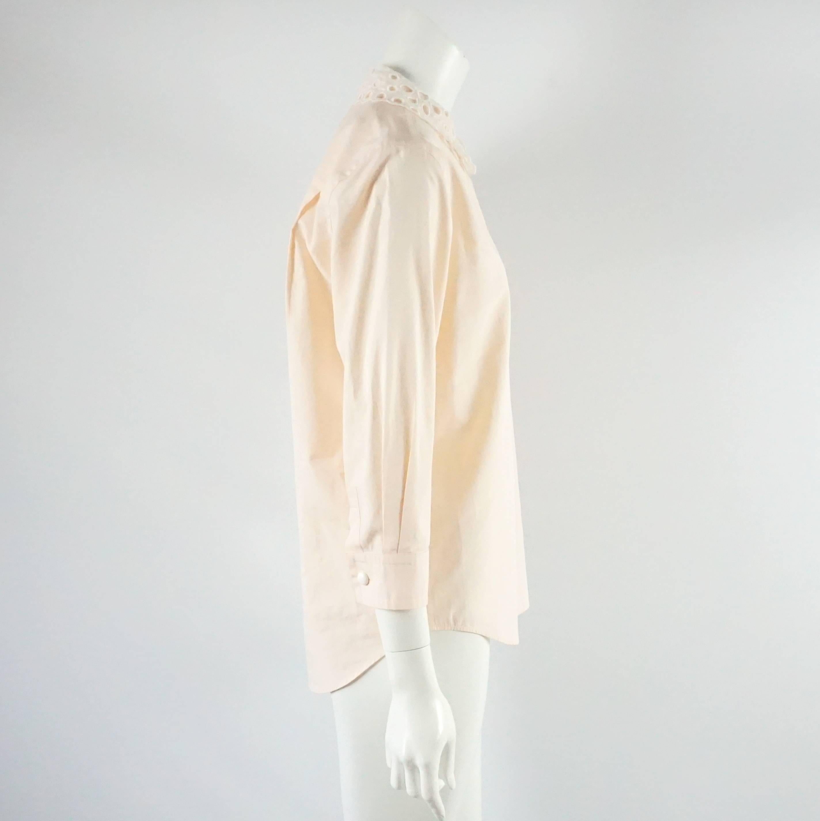 This Louis Vuitton long sleeved top is made of pink / peach colored cotton. It has a removable collar and buttons. This top is in excellent condition. Size 38.

Measurements
Shoulder to Shoulder: 16.25"
Sleeve Length: 19.25"
Bust: