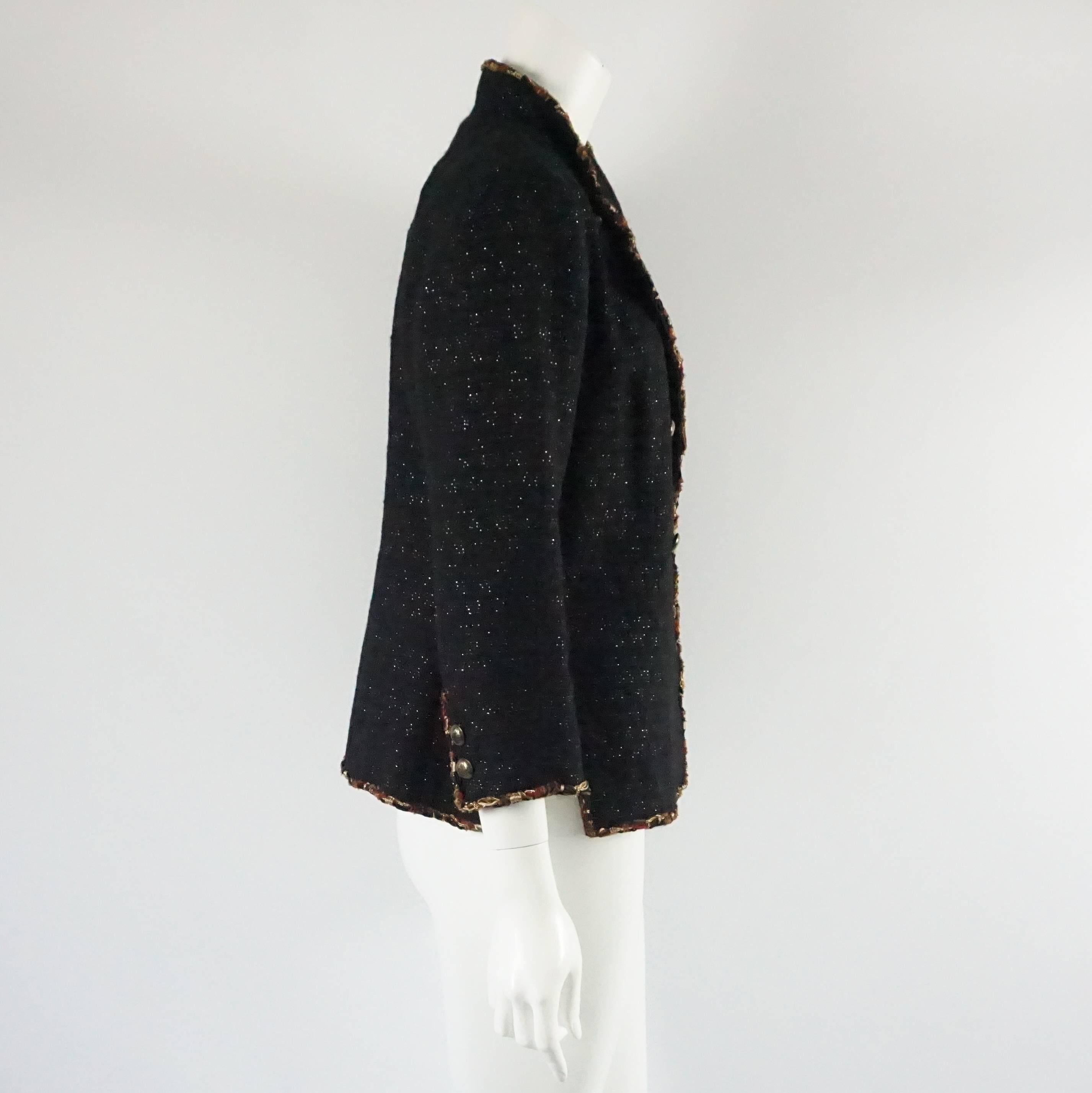 This Chanel black wool jacket has an amber chain trim. This jacket features a collar, 2 buttons on each cuff, and a double breasted design. This jacket is in excellent condition. Size 42.

Measurements
Shoulder to Shoulder: 16"
Sleeve Length: