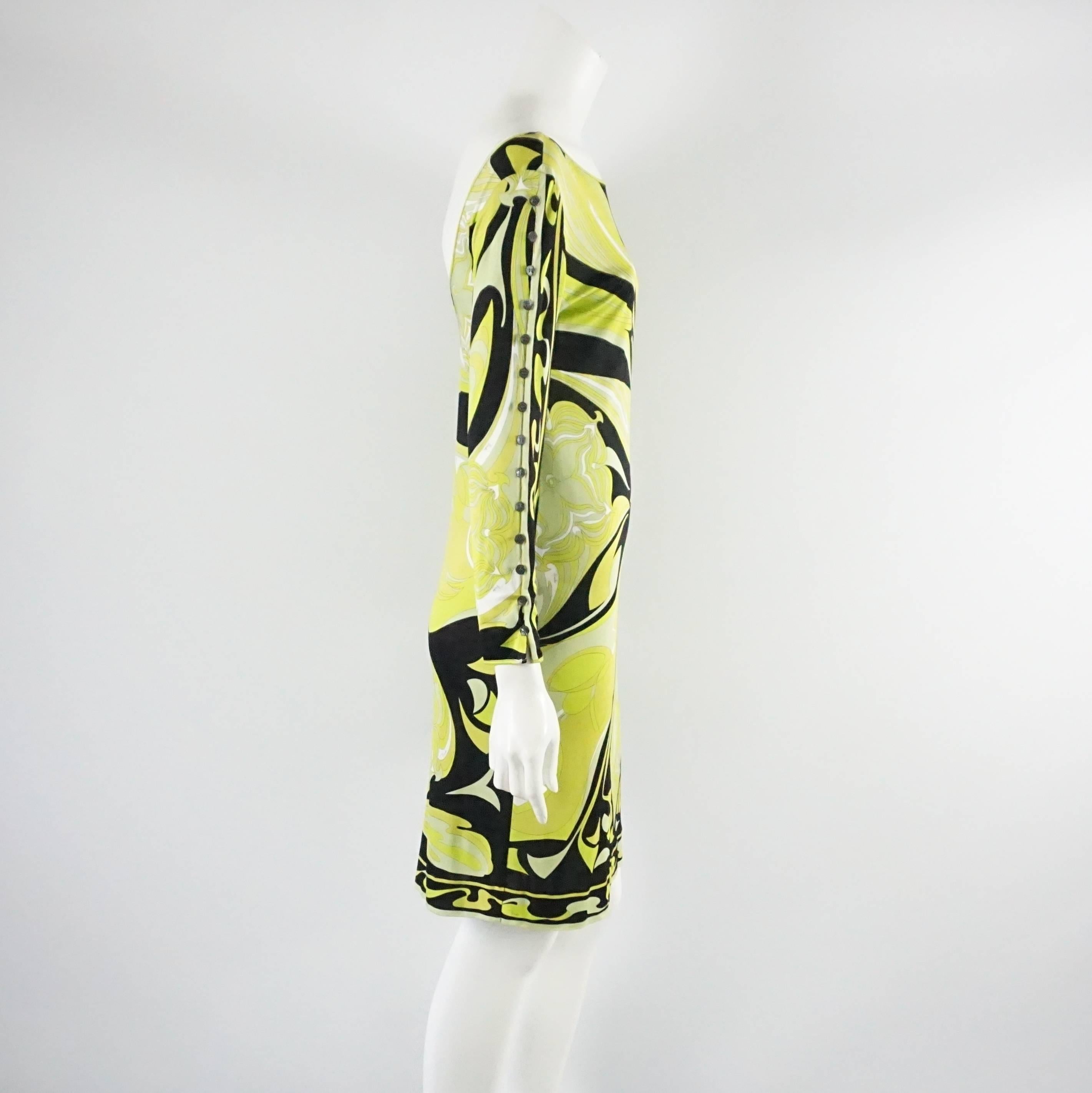 This Emilio Pucci dress has a lime green, chartreuse, and black floral print. It is also long sleeved with buttons going all down each arm and a lower cut back. The dress is in good condition with a few pulls and small discolorations as seen in the