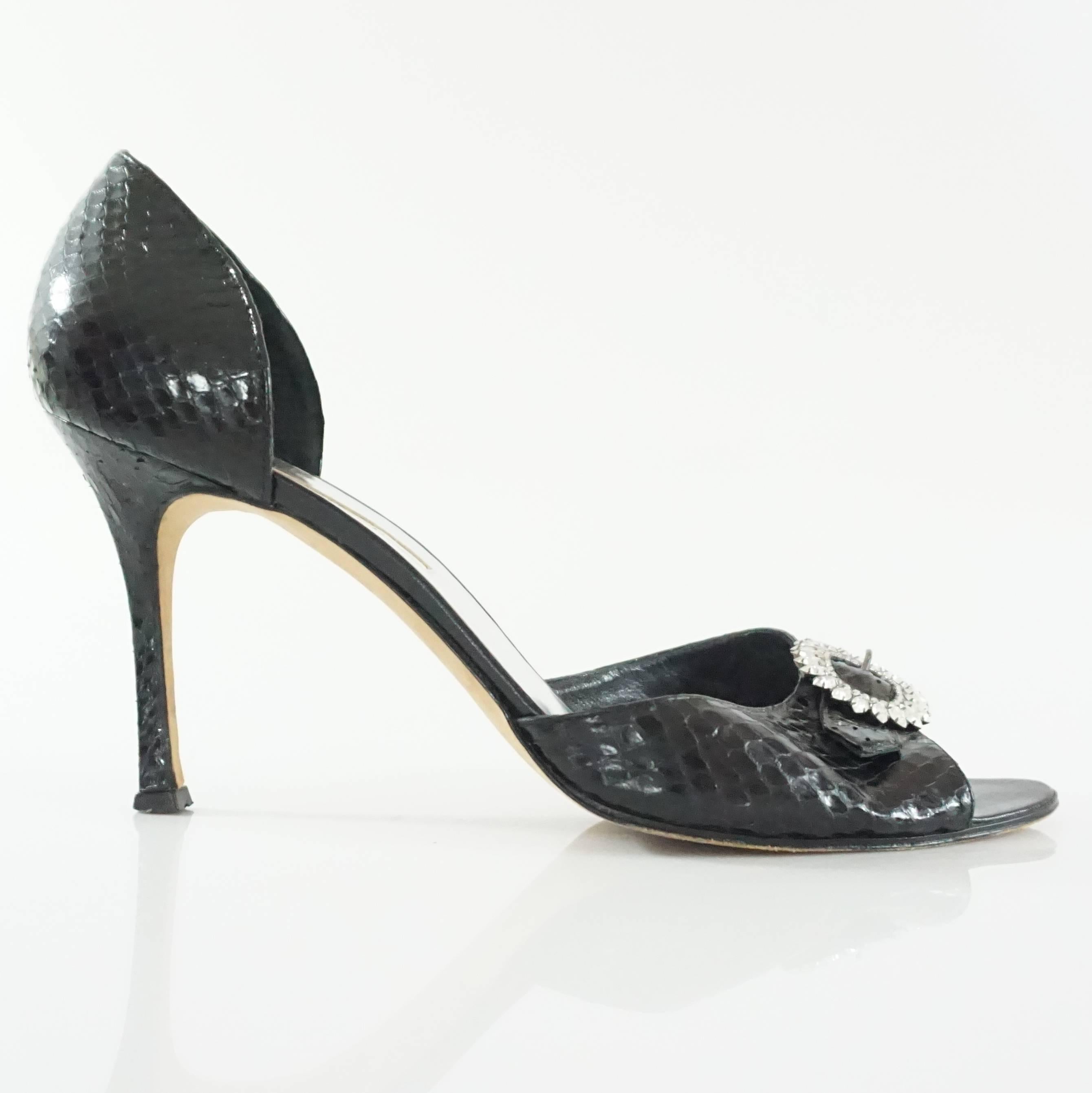 These Manolo Blahnik black snake heels are a d'orsay style and have a rhinestone encrusted buckle by the toe bed. They are in excellent condition with minimal wear on the bottom. Size 41. 

Measurements
Platform: 0.5"
Heel: 3.75"