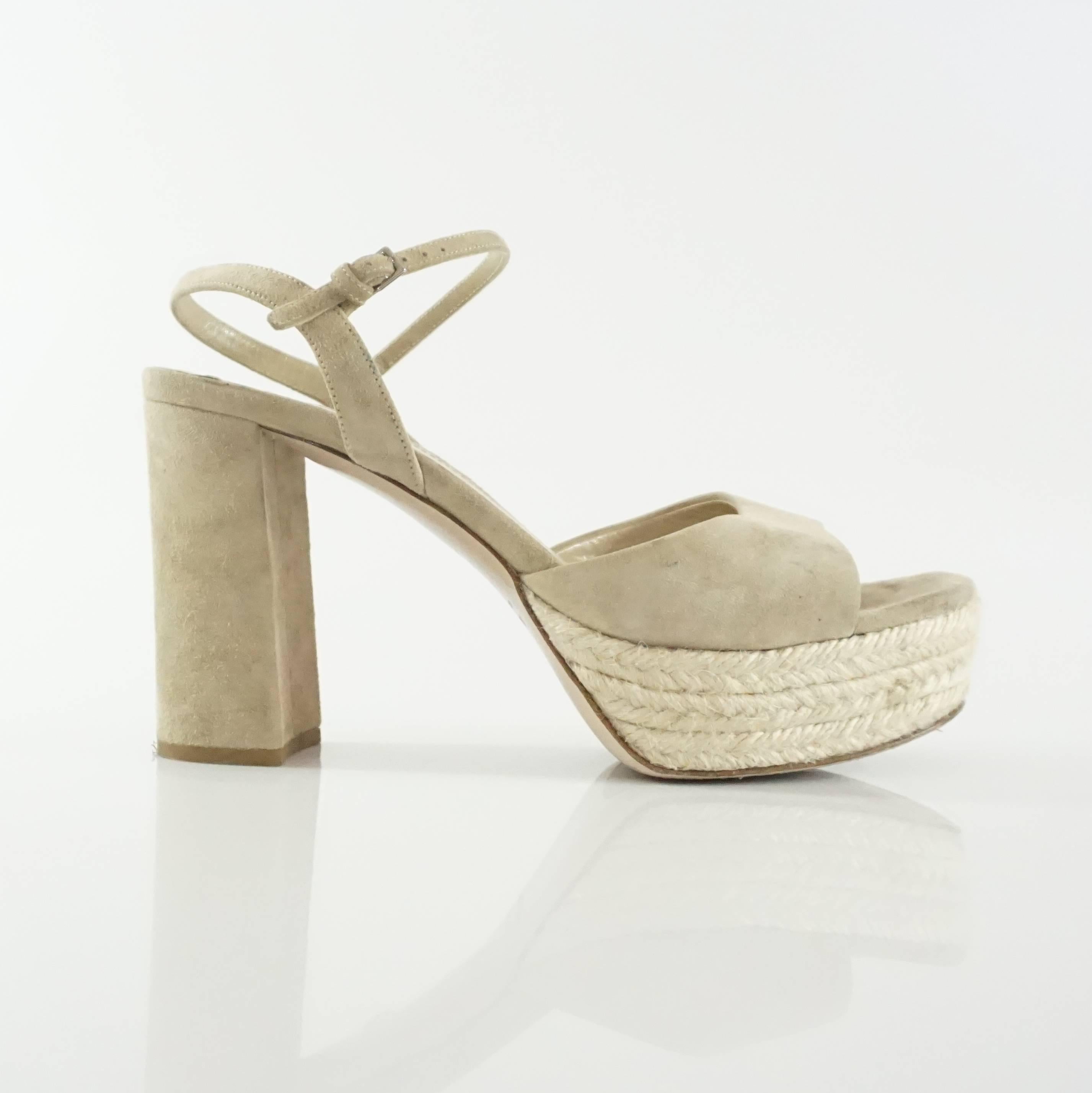 These Miu Miu nude suede sandals have a chunky heel and ankle strap. The heels are open toe and the platform is made of straw. They are in good condition with some wear to the suede, bottom, and straw as indicated in the images. Size 36.