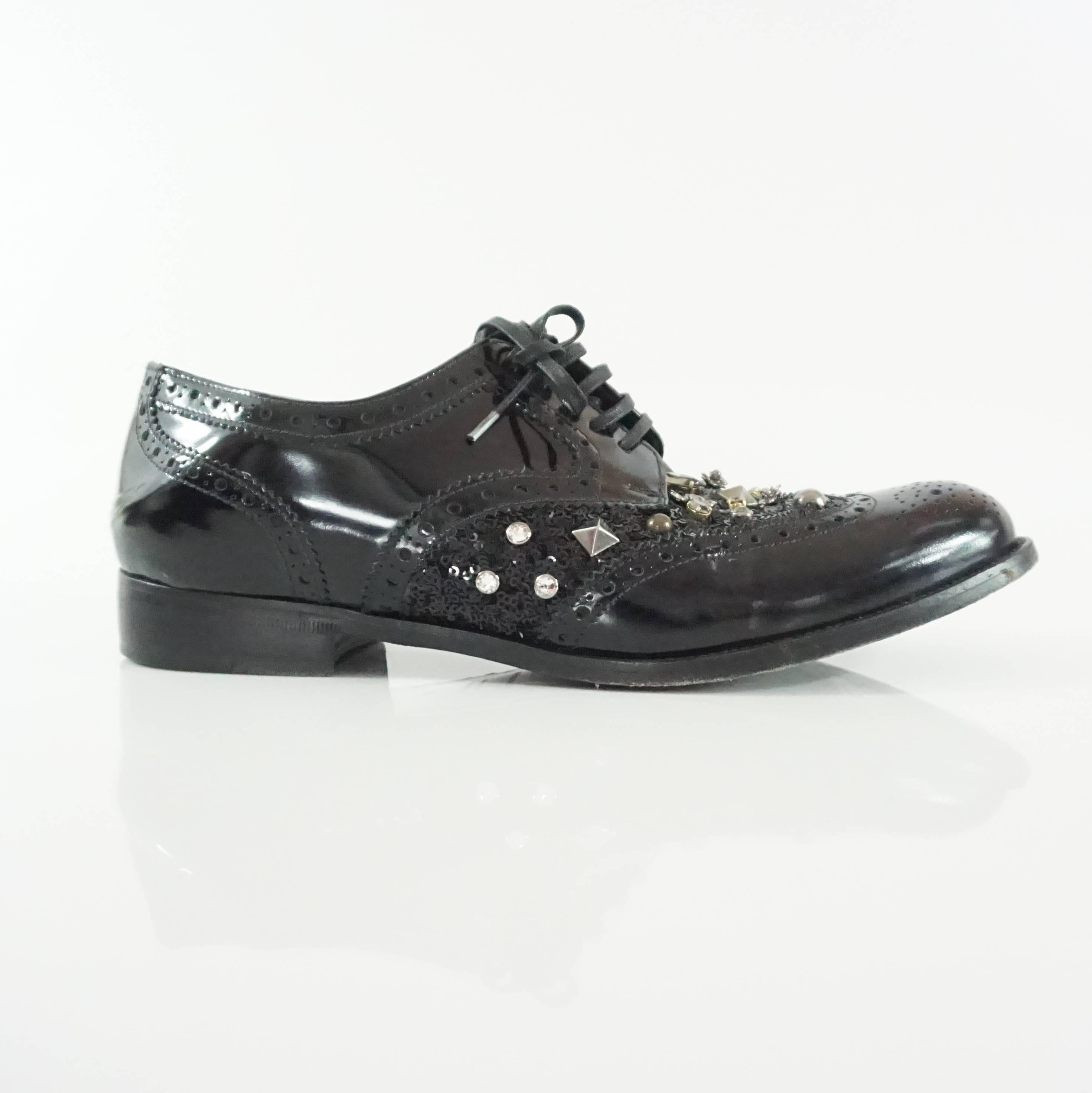 These stunning Dolce & Gabbana black lace-up oxfords are a fabulous twist on a classic style. They have sequin encrusting with studs and rhinestones in the middle. They are in excellent condition with minimal wear to the leather and the bottom.