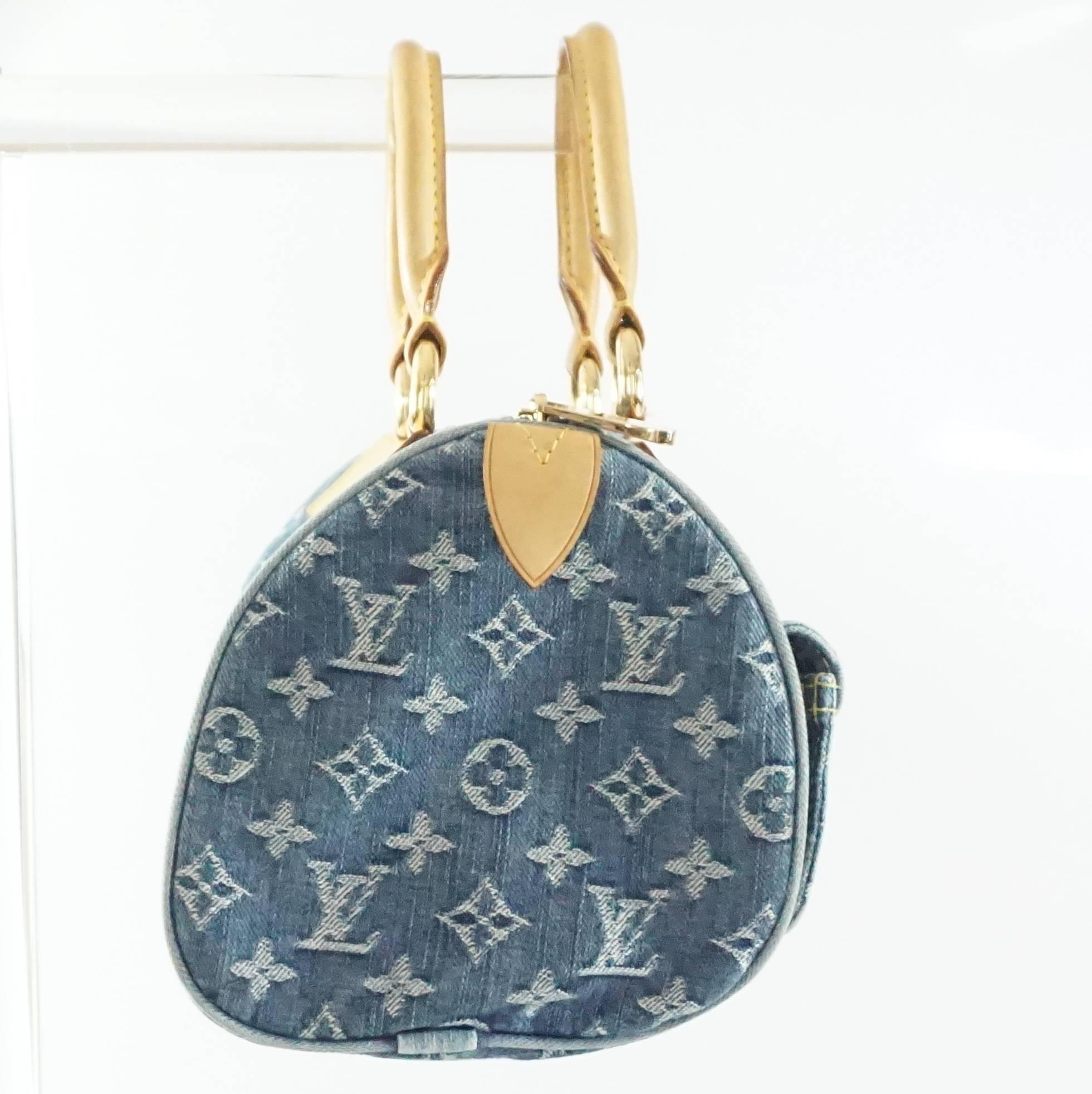 This Louis Vuitton blue jean bag has a monogram print all over with luggage leather detailing. This top handle bag has 2 front exterior pockets, 1 exterior zip pocket, and 1 small interior open pocket. The piece is in fair condition with some small