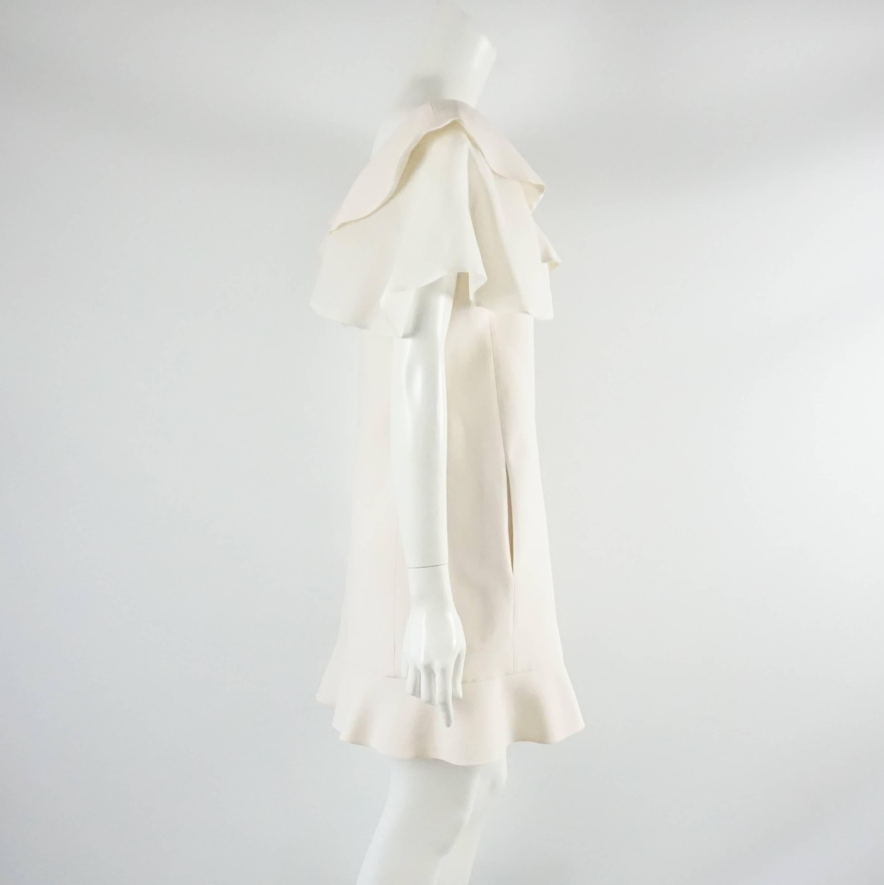 This Valentino ivory dress has ruffles along the neckline and bottom. It is a wool-silk blend with a back zipper. The dress is in excellent condition with minimal fabric wear. Size 6. 

Measurements
Bust: 36"
Waist: 33"
Hips: